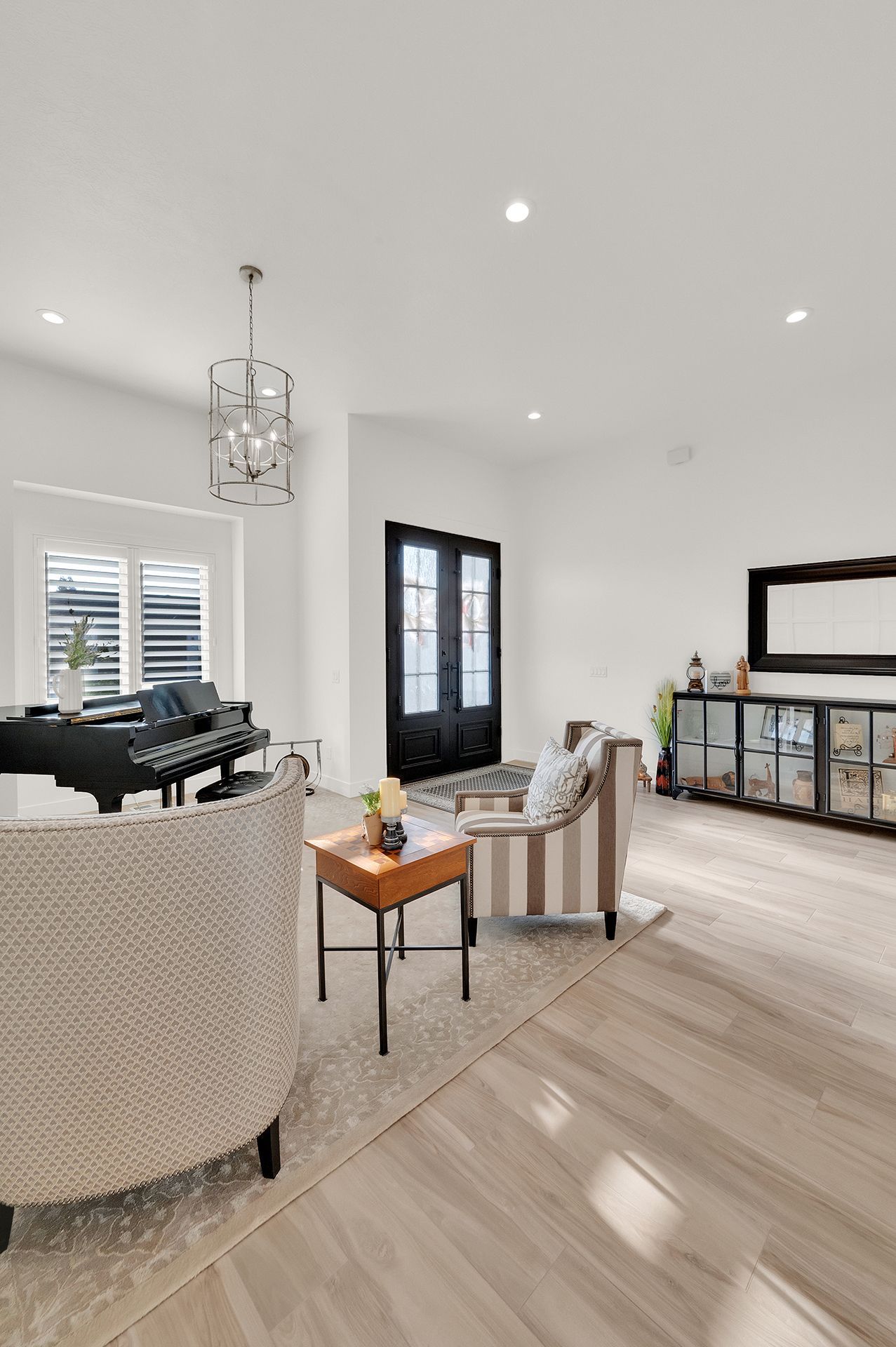 A living room with a piano , couch , chairs and a table.