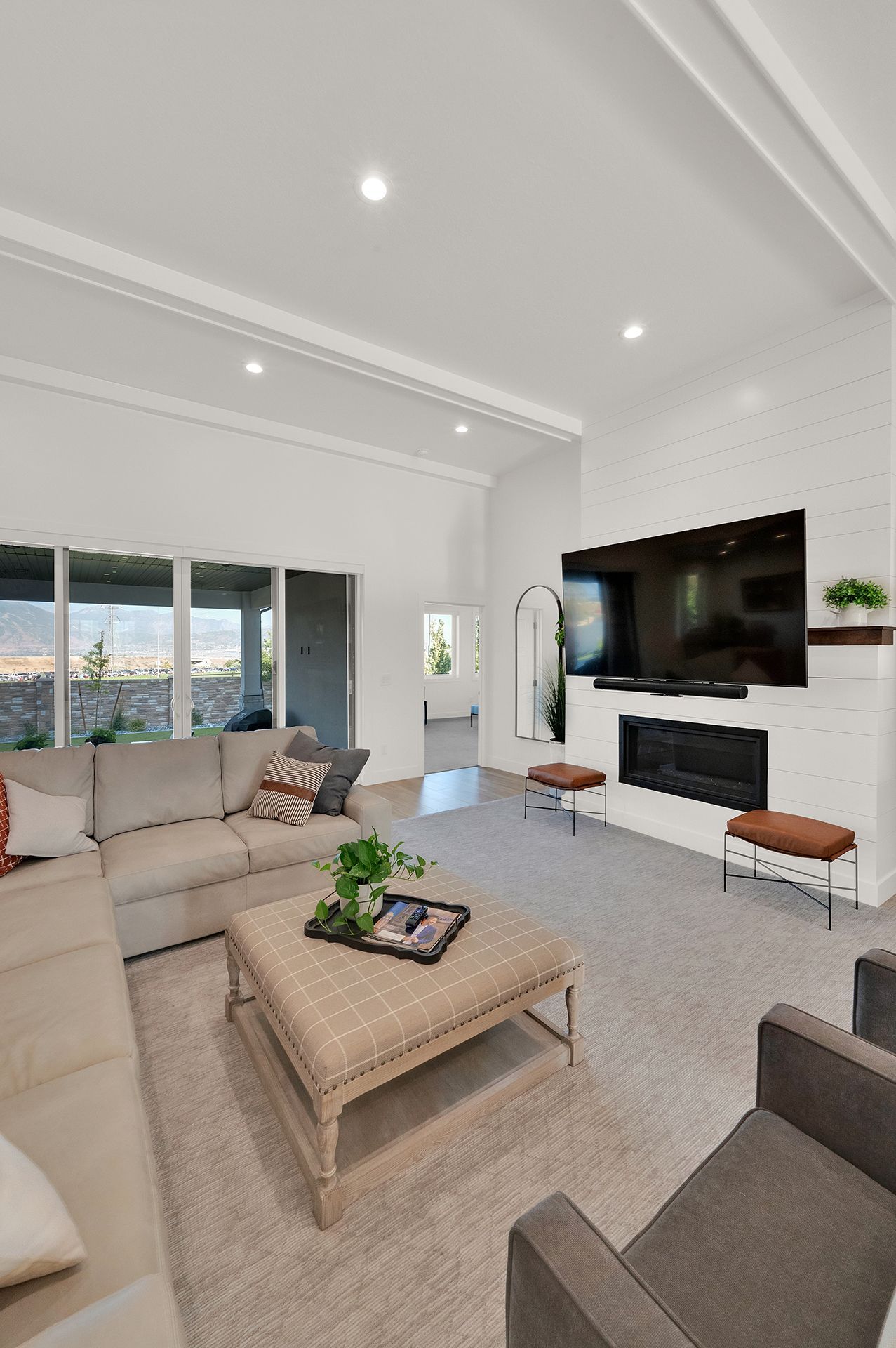 A living room with a couch , chair , coffee table , television and fireplace.