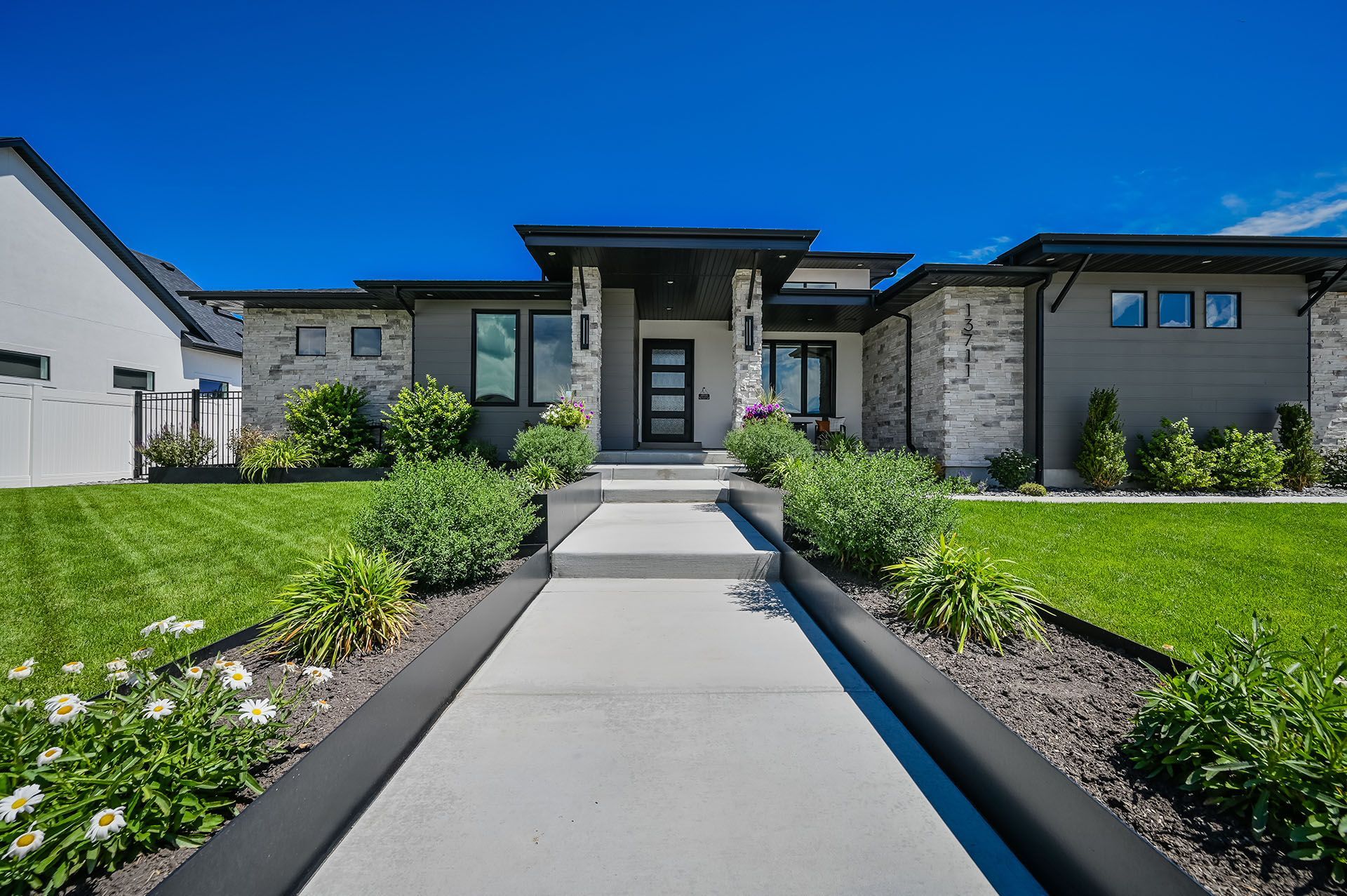 A large house with a concrete walkway leading to the front door.