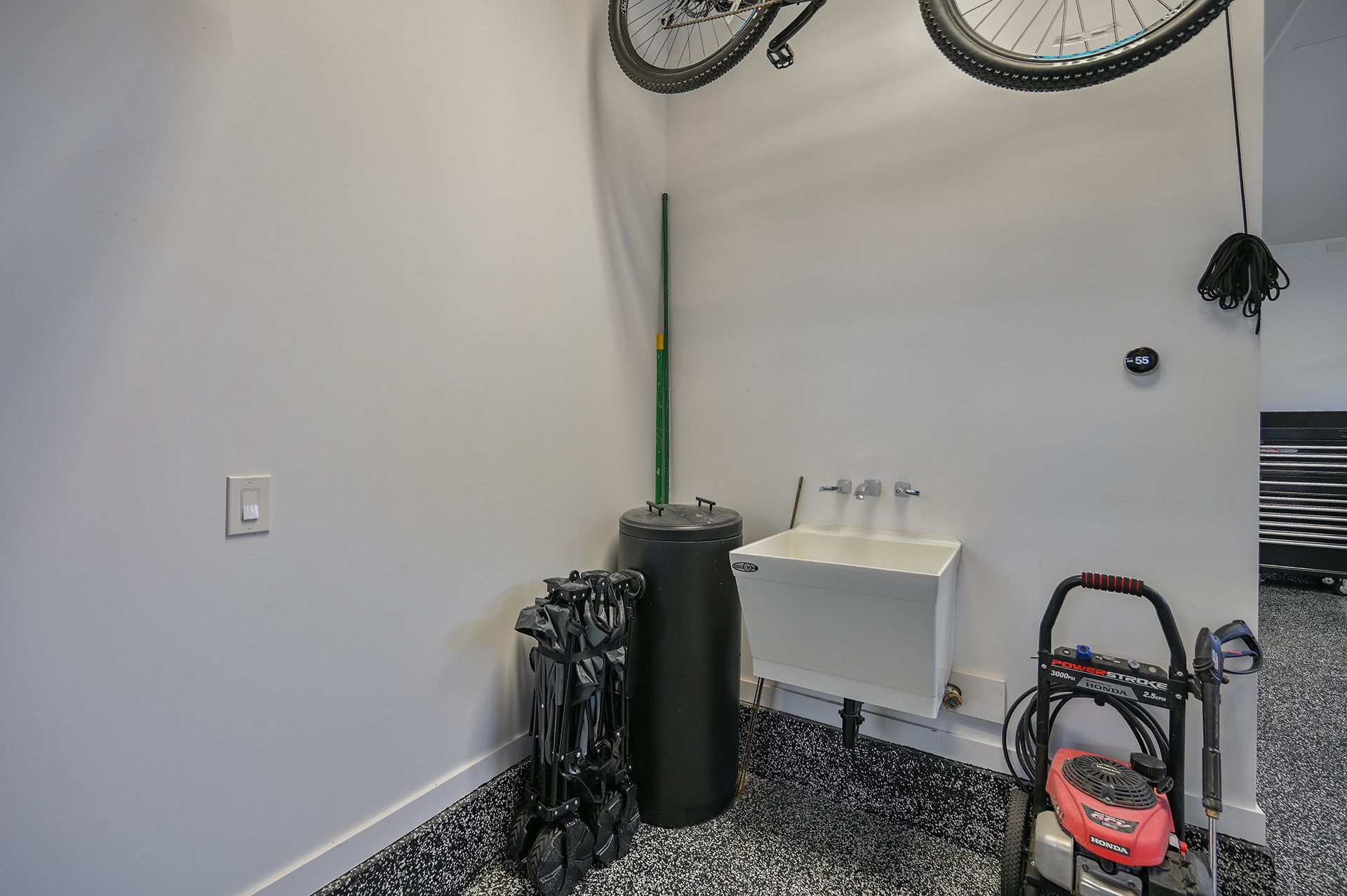 A bicycle is hanging from the wall in a garage.