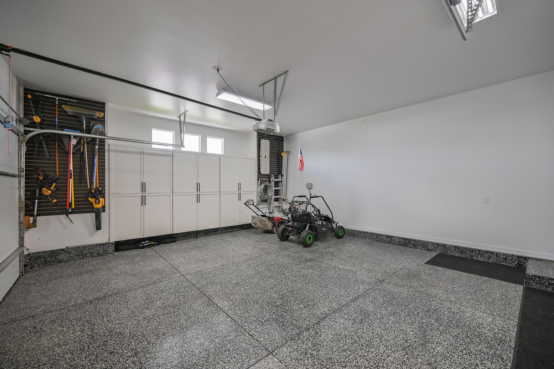 A large empty garage with a lawn mower in it.