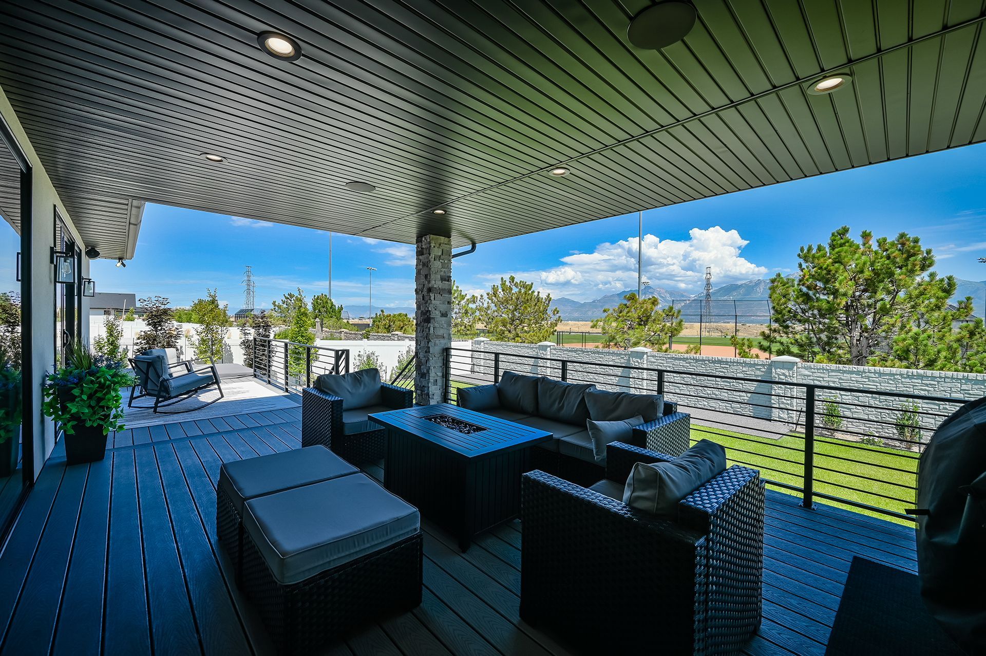 A large patio with a lot of furniture and a view of the mountains.
