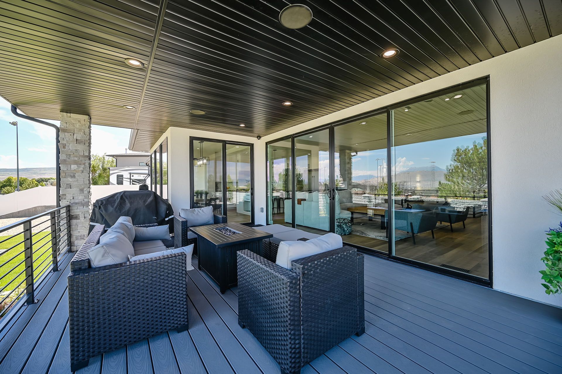 A balcony with wicker furniture and sliding glass doors leading to a living room.