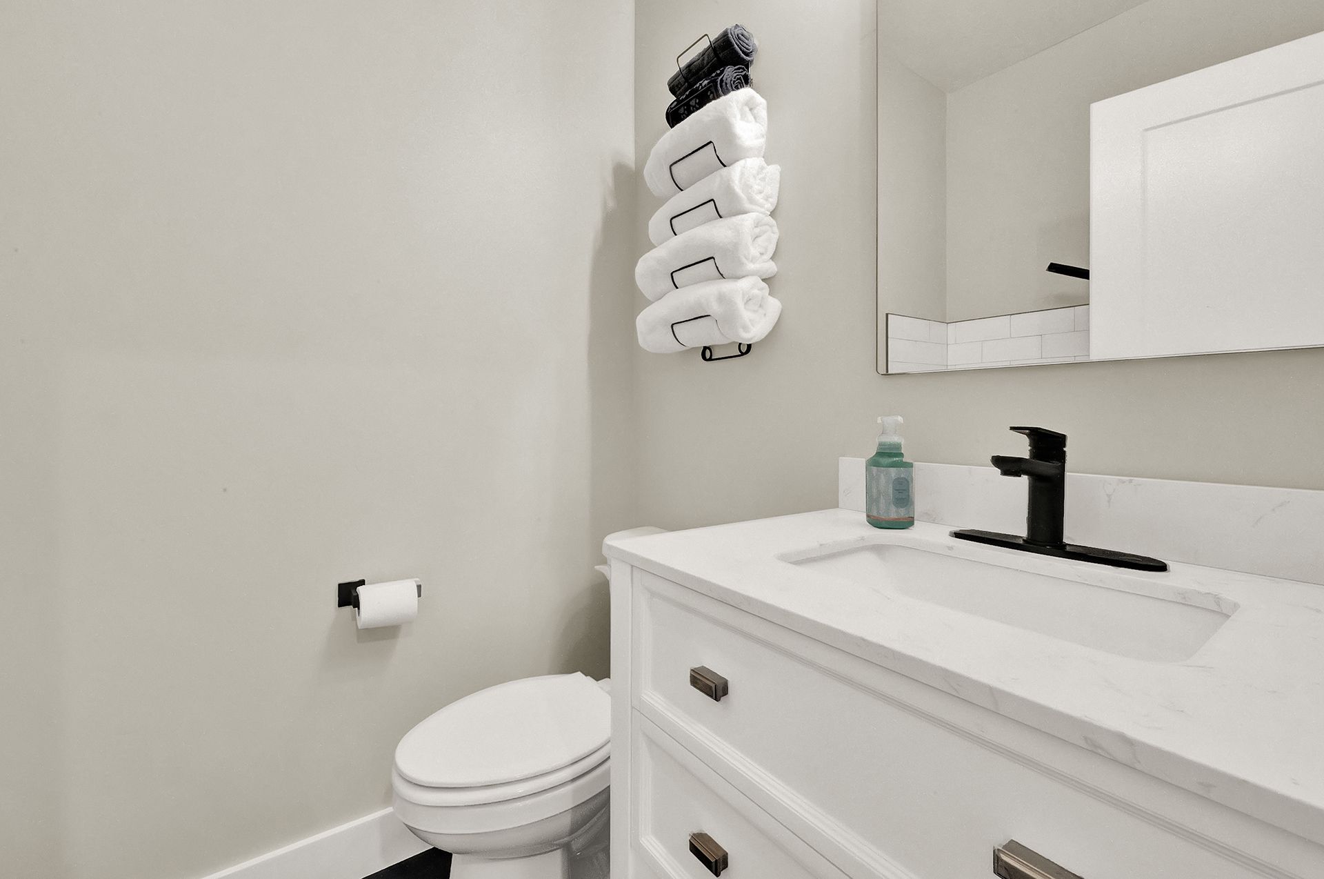 A bathroom with a toilet , sink and mirror.