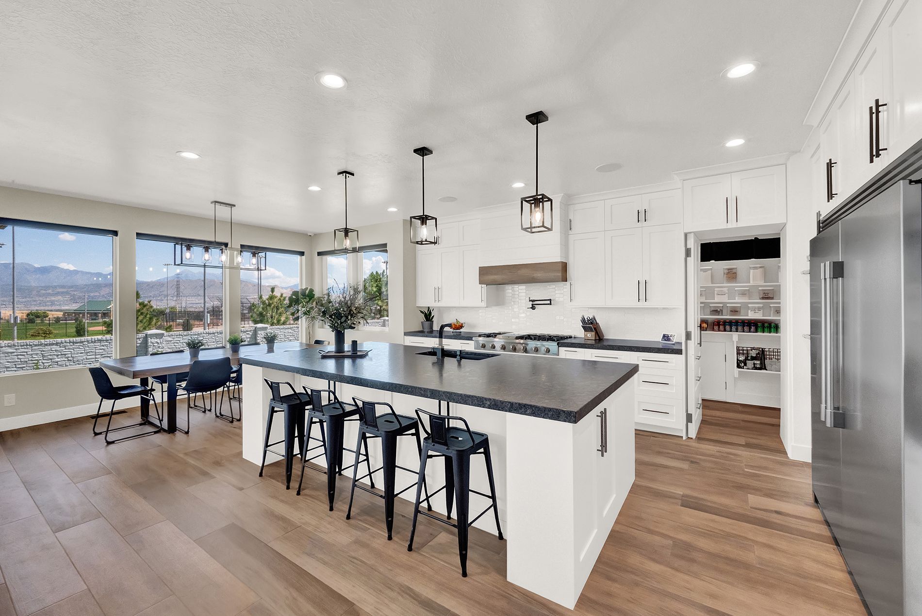 A kitchen with white cabinets and stainless steel appliances and a large island.