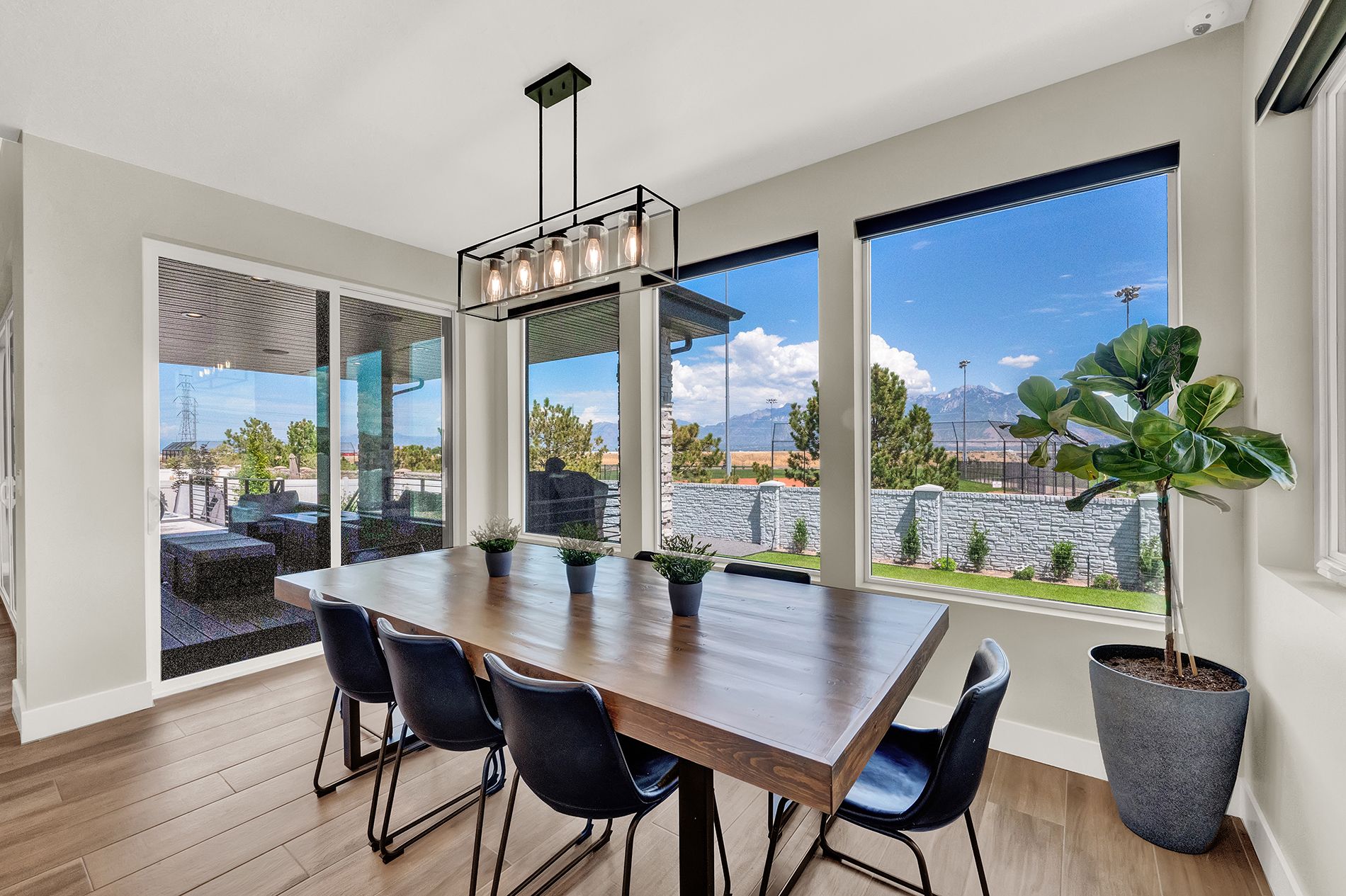 A dining room with a long wooden table and chairs.