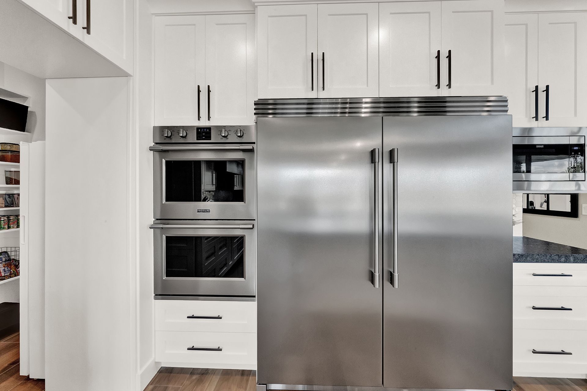 A kitchen with stainless steel appliances and white cabinets.