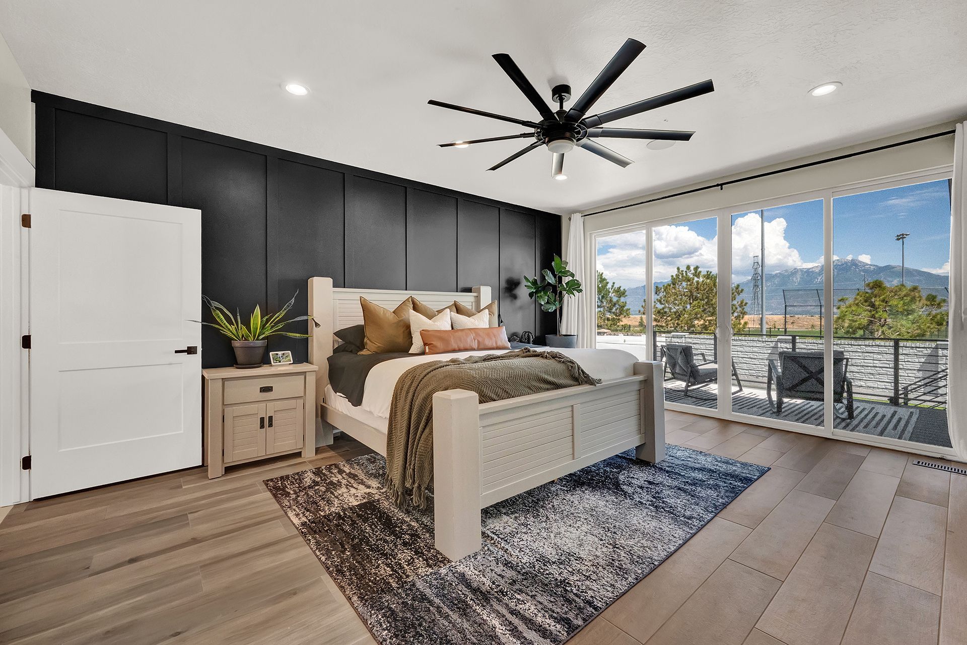 A bedroom with a large bed and a ceiling fan.