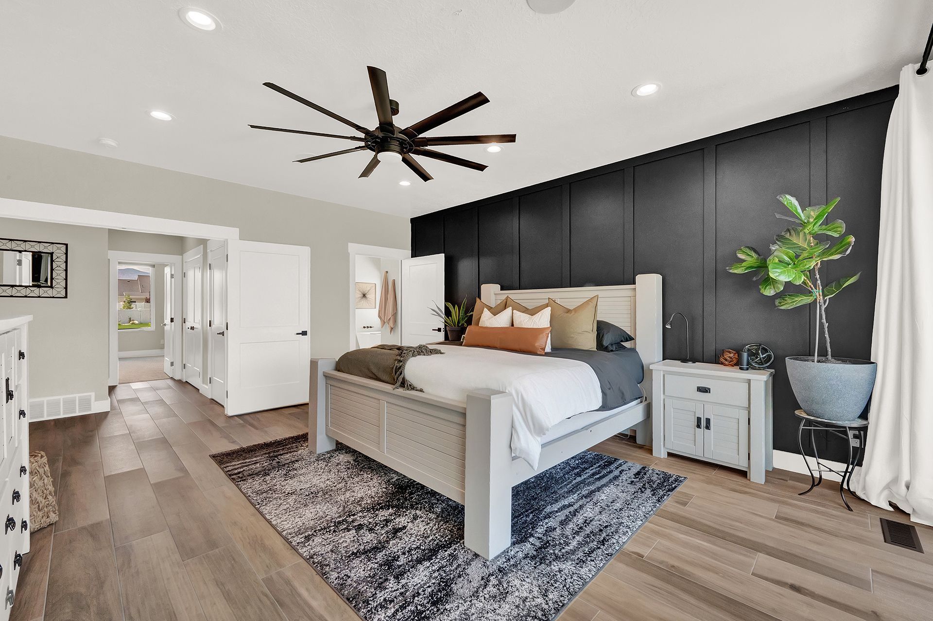 A bedroom with a large bed and a ceiling fan.