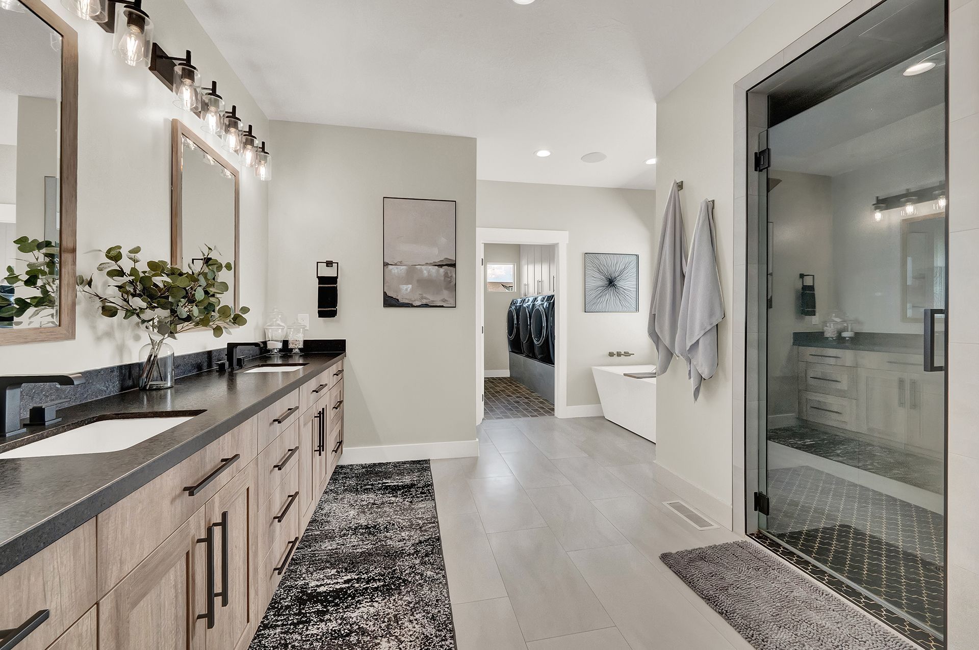 A bathroom with two sinks and a walk in shower.