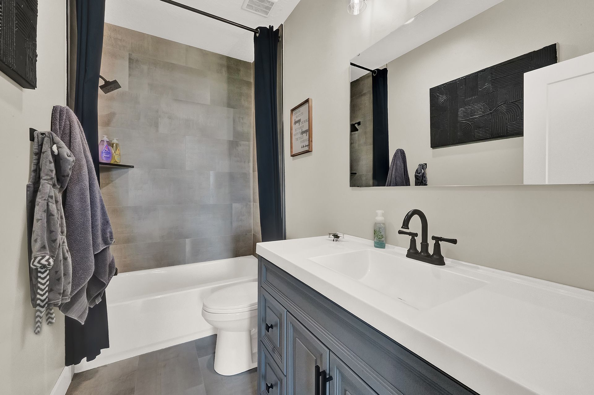 A bathroom with a sink , toilet , bathtub and mirror.