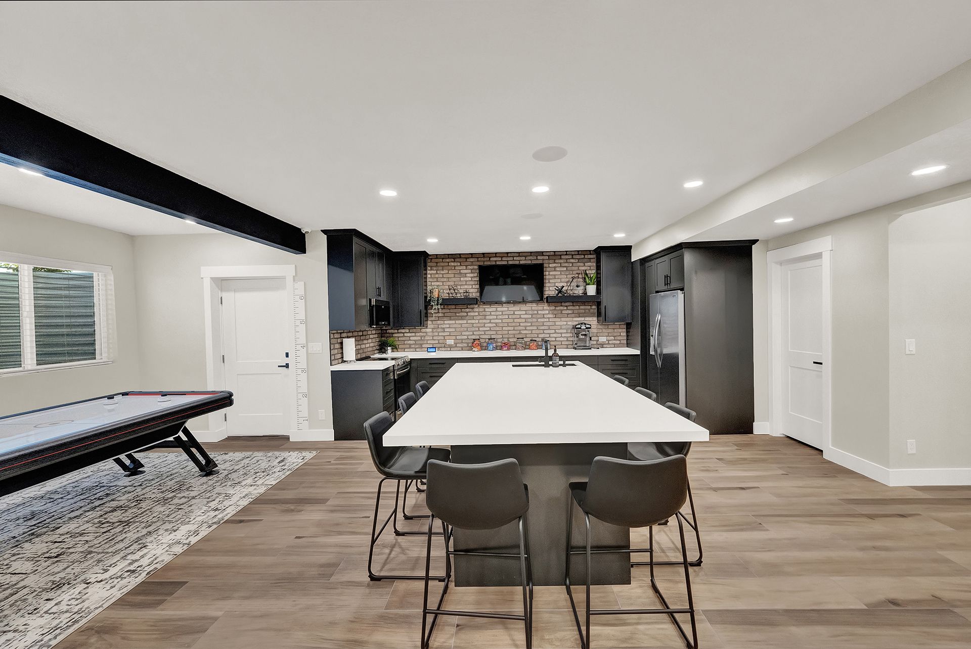 A kitchen with a large island and a pool table.