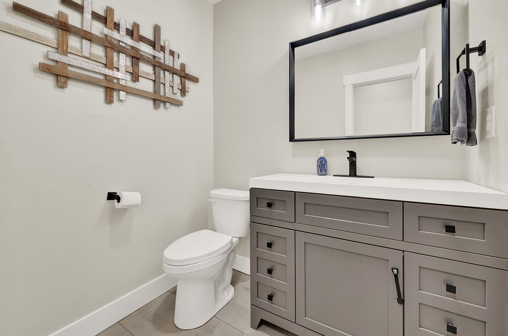 A bathroom with a toilet , sink and mirror.