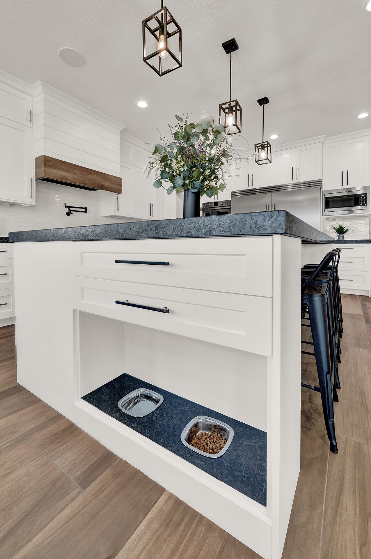 A kitchen with two dog bowls on the island.