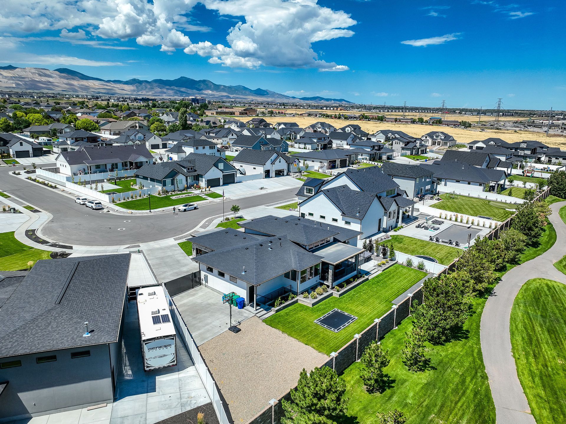 An aerial view of a residential neighborhood with a rv parked in the middle of the street.