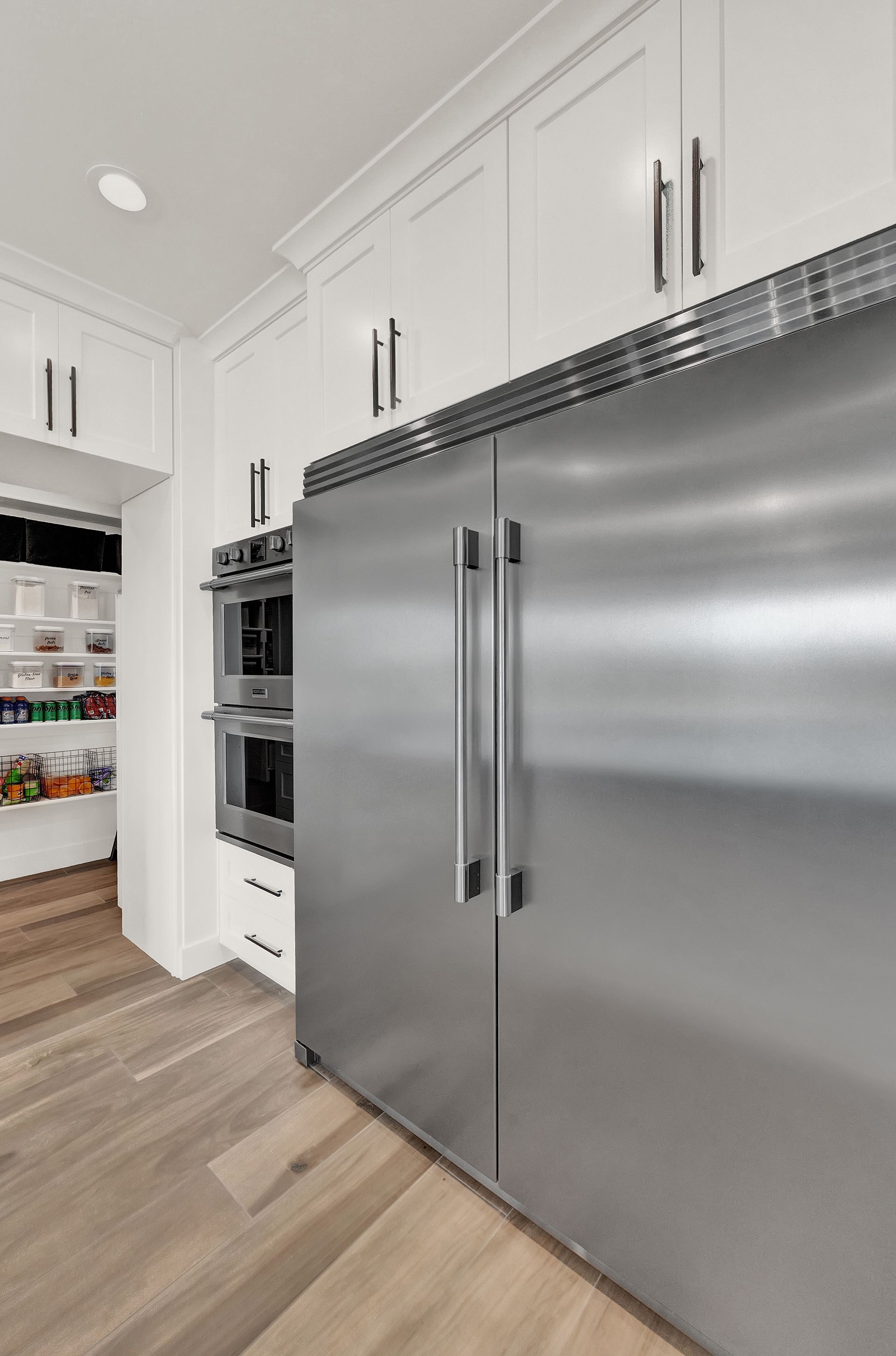 A kitchen with stainless steel appliances and white cabinets.