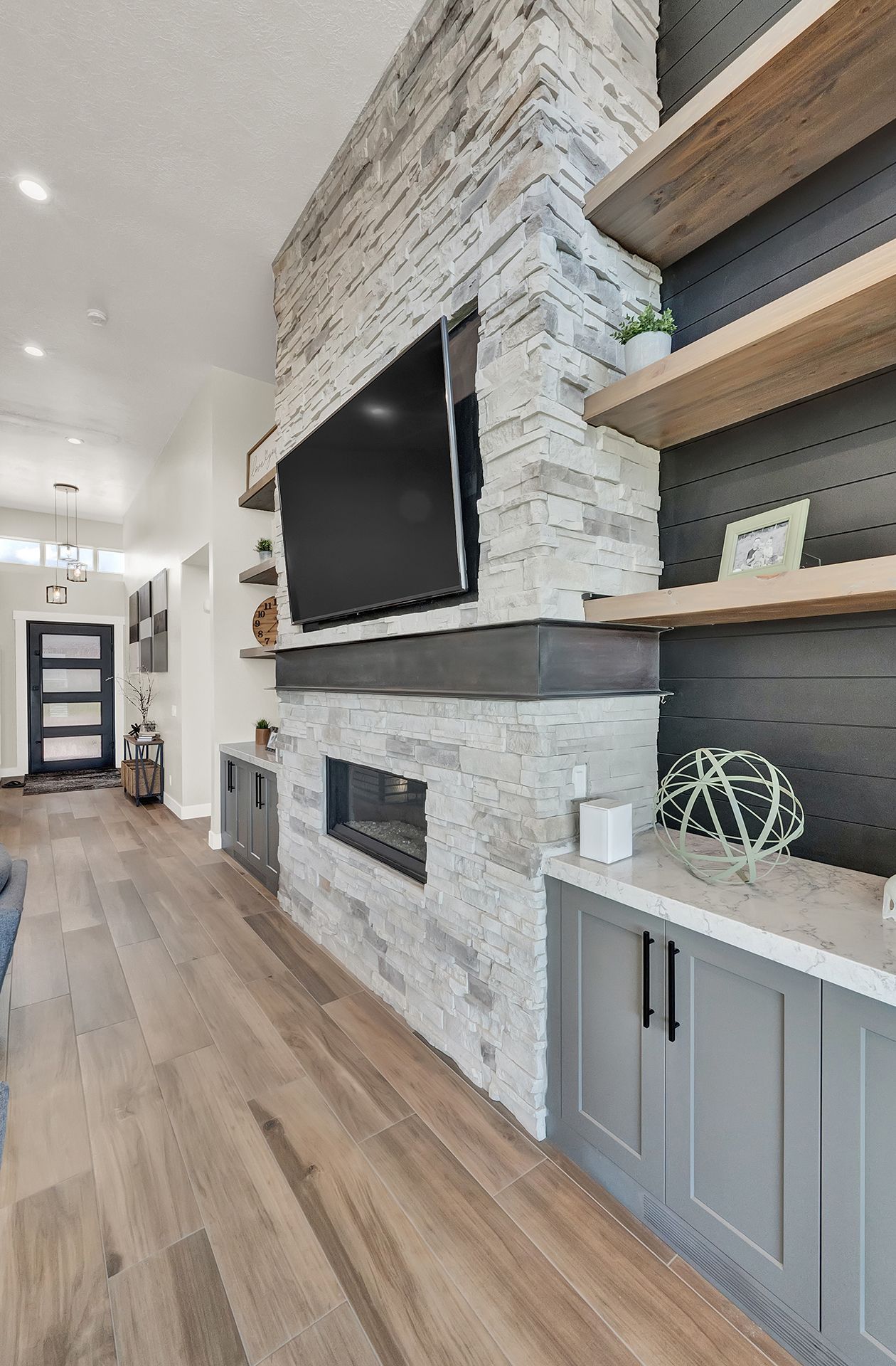 A living room with a fireplace and a flat screen tv on the wall.