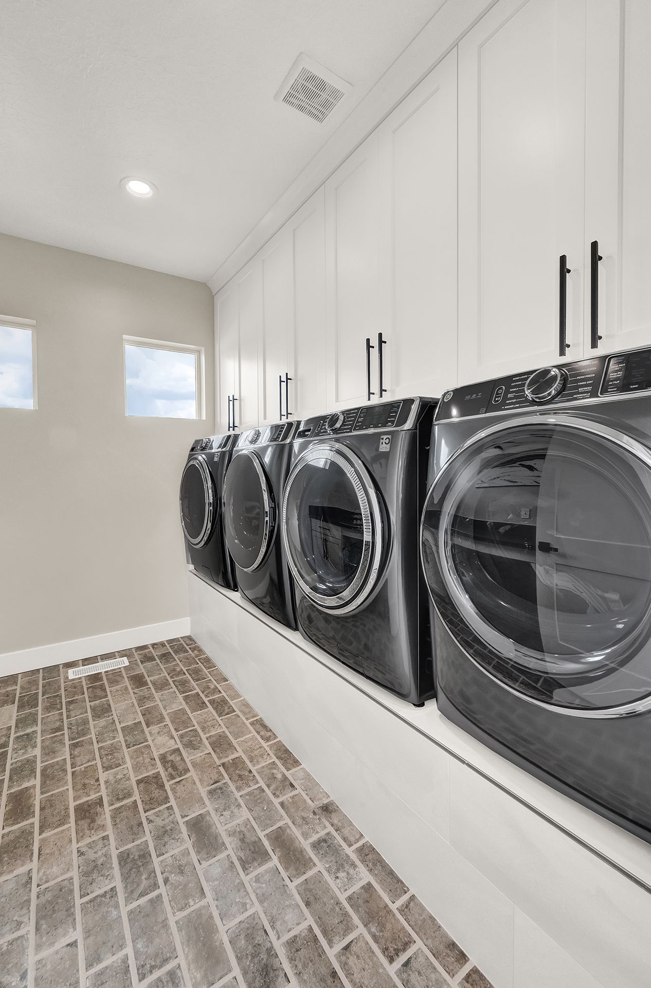 A laundry room with a row of washers and dryers.