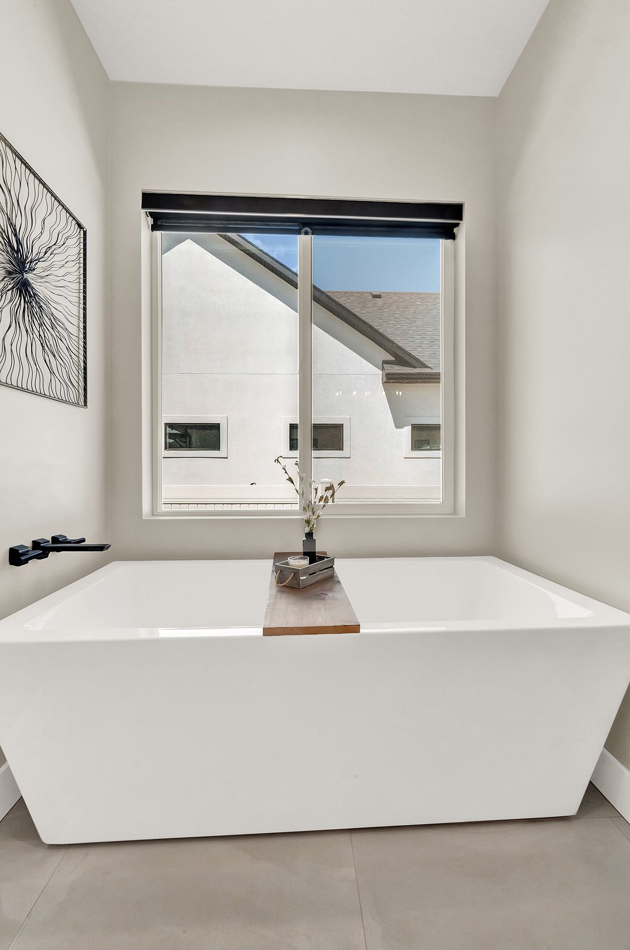 A bathtub in a bathroom next to a window.