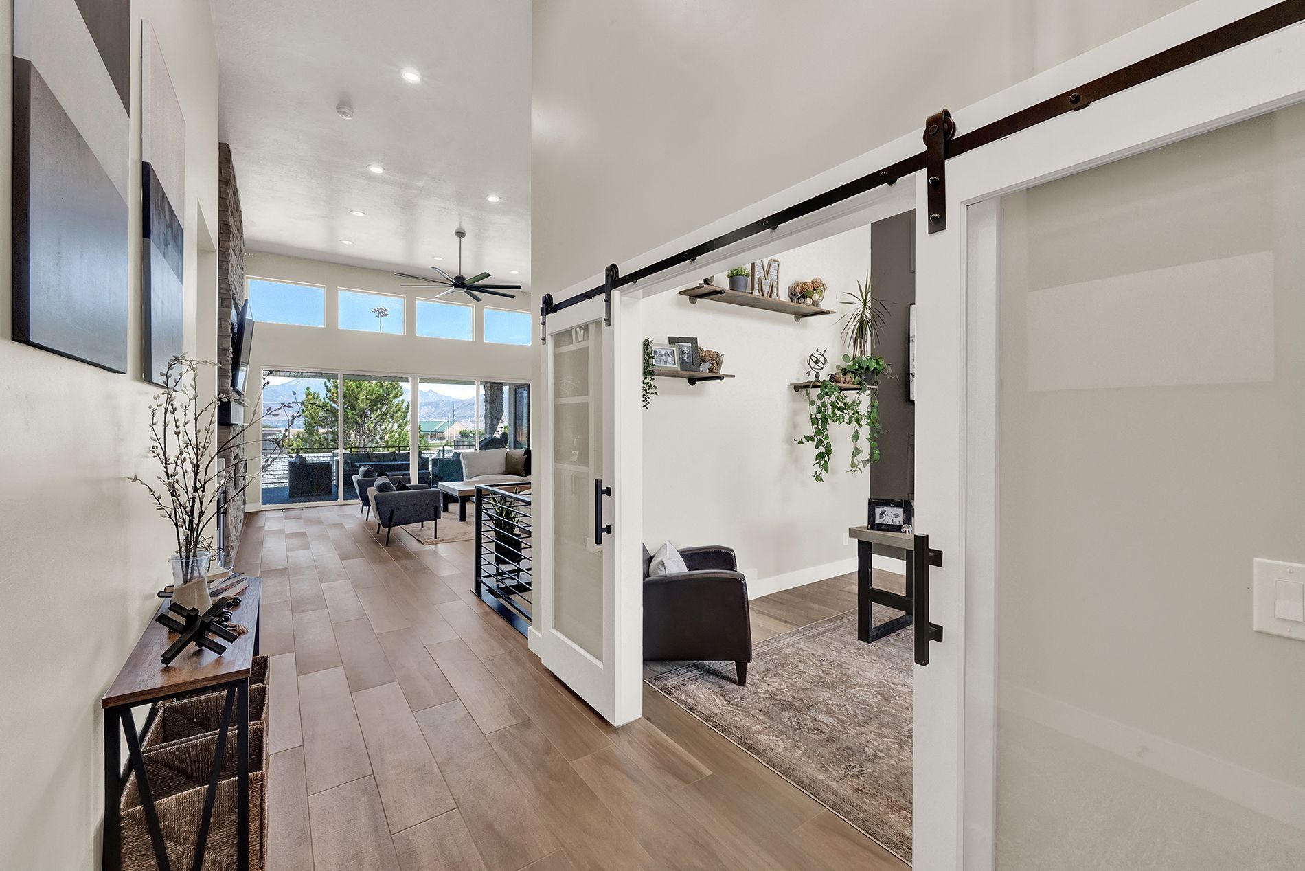 A hallway in a house with sliding barn doors leading to a living room.