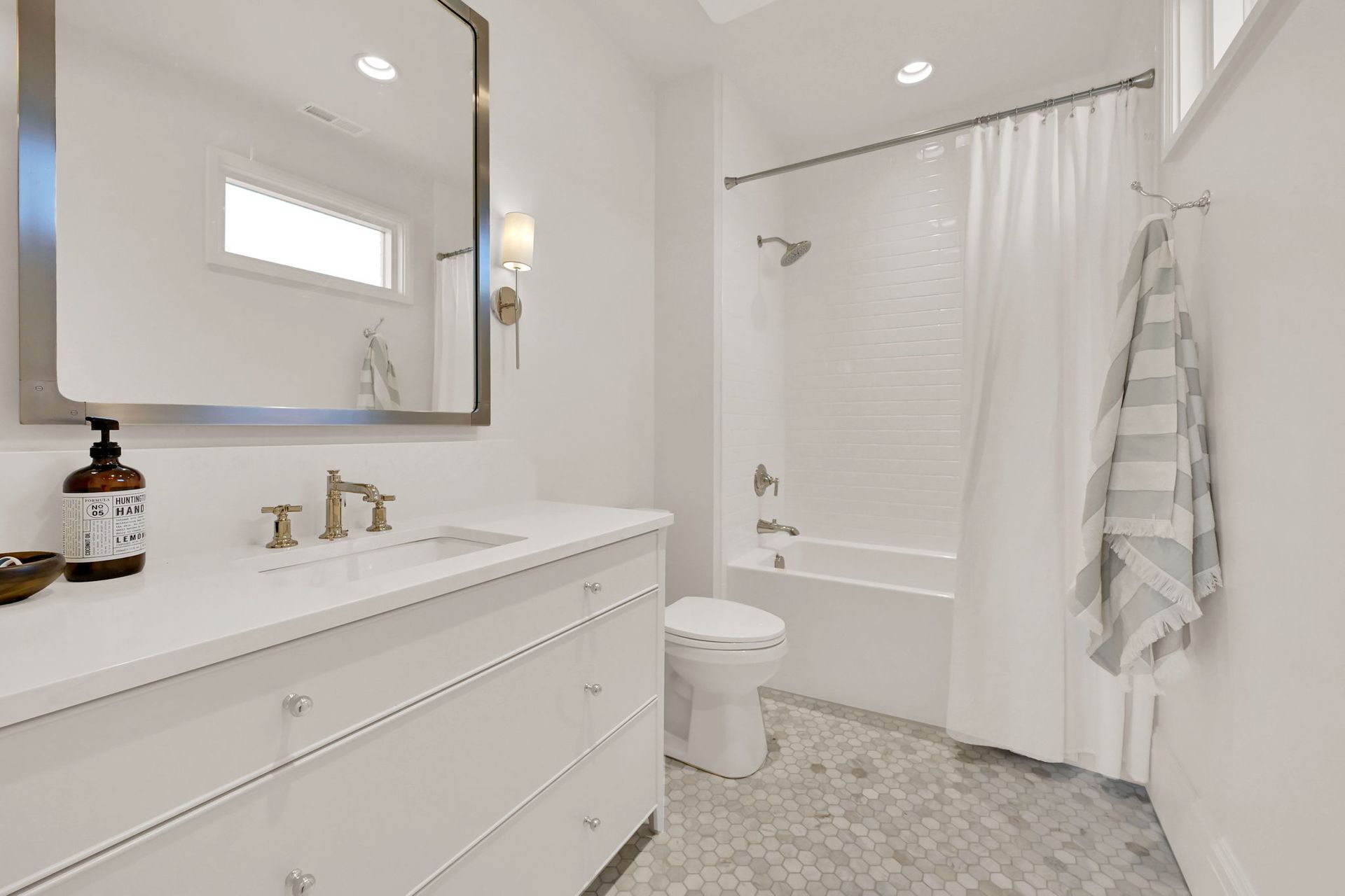 A bathroom with a toilet , sink , mirror and bathtub.