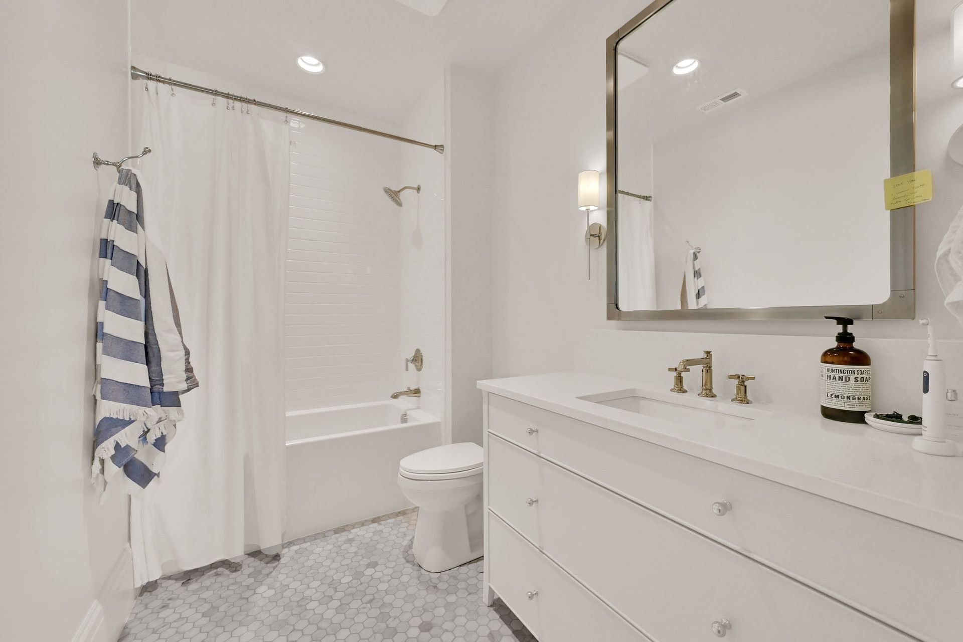 A bathroom with a toilet , sink , mirror and bathtub.