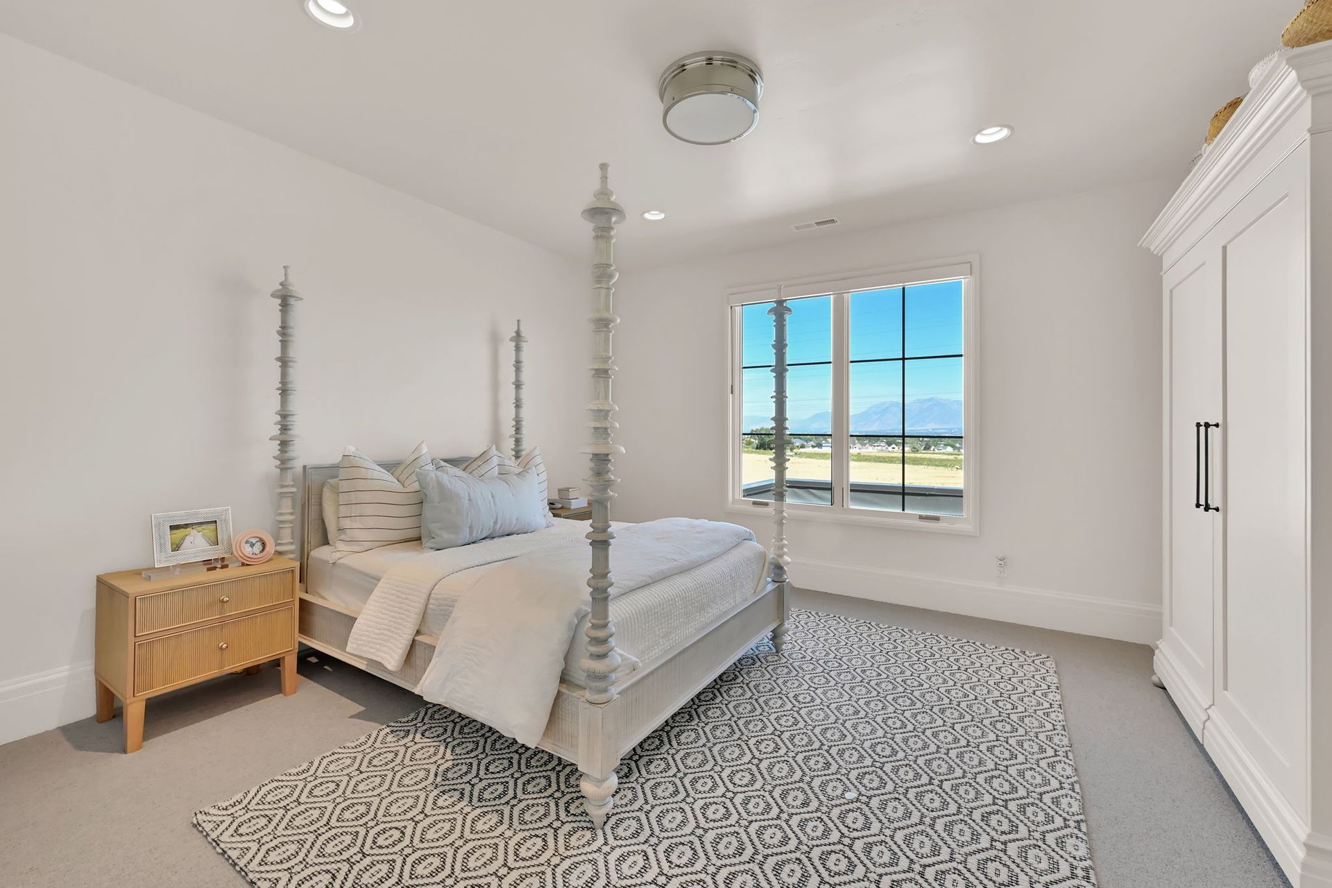 A bedroom with a four poster bed and a rug.