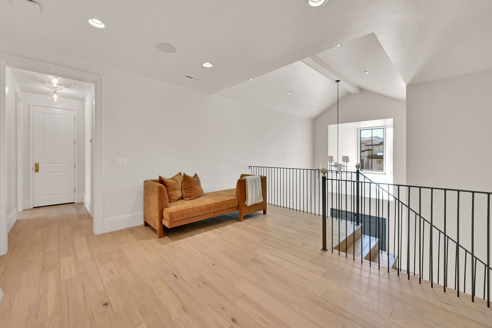 A hallway with a couch and stairs in a house.