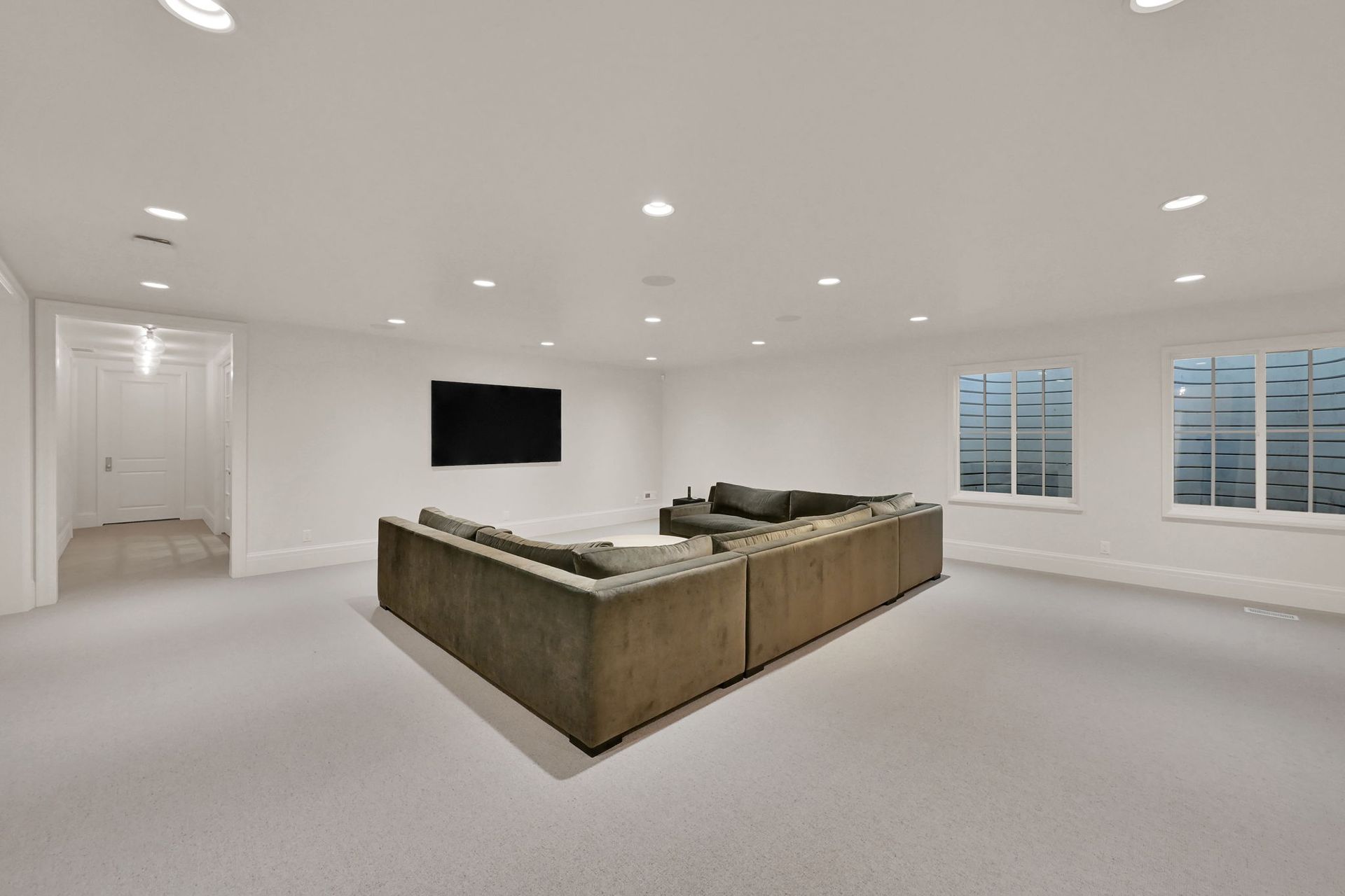 A living room with a large couch and a flat screen tv.
