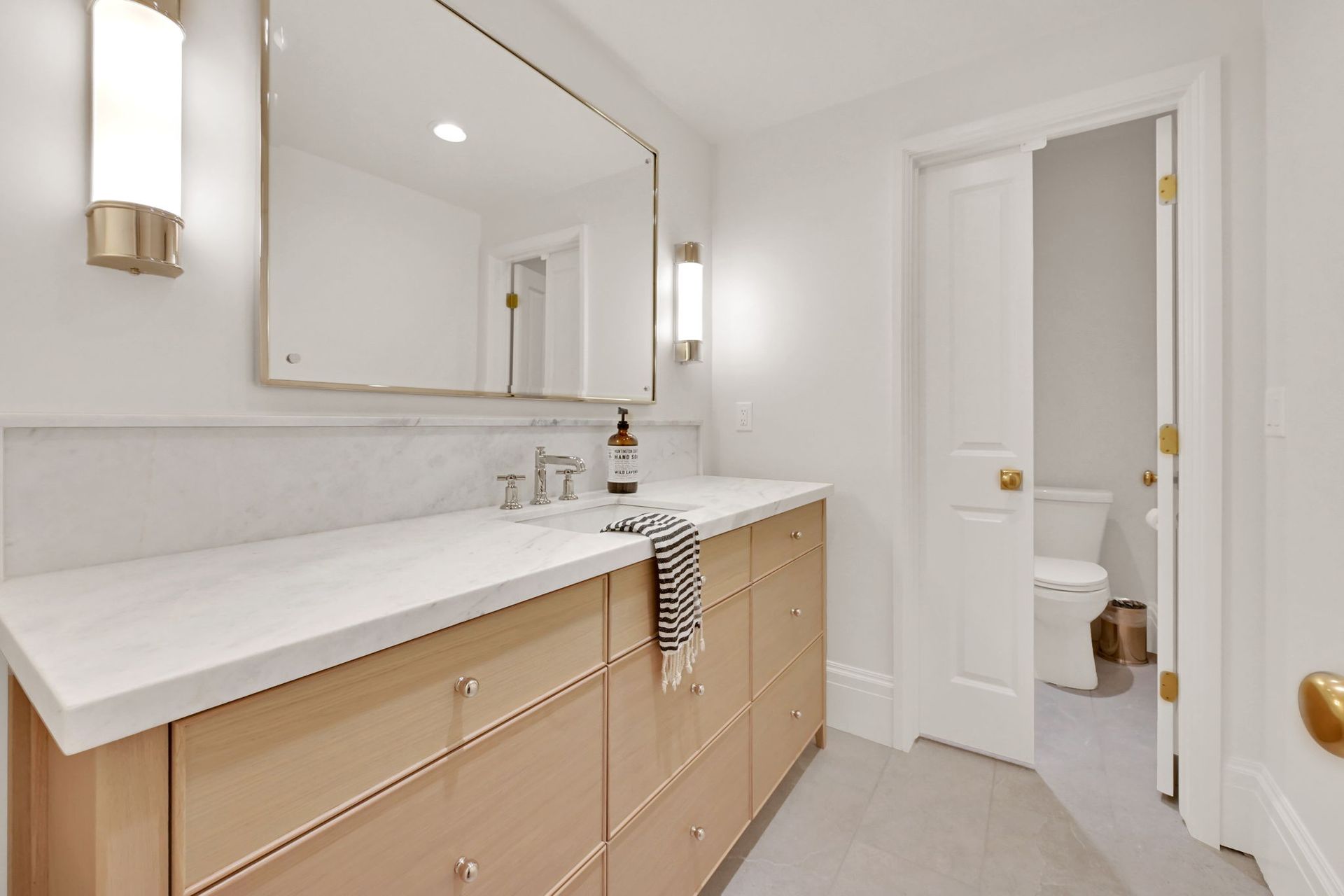 A bathroom with two sinks , a mirror and a toilet.