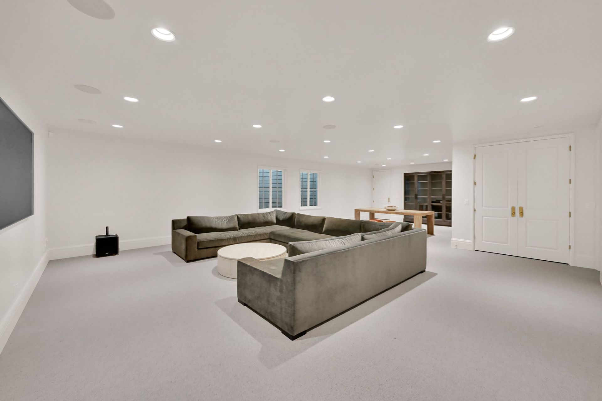 A living room with a large sectional couch and a flat screen tv