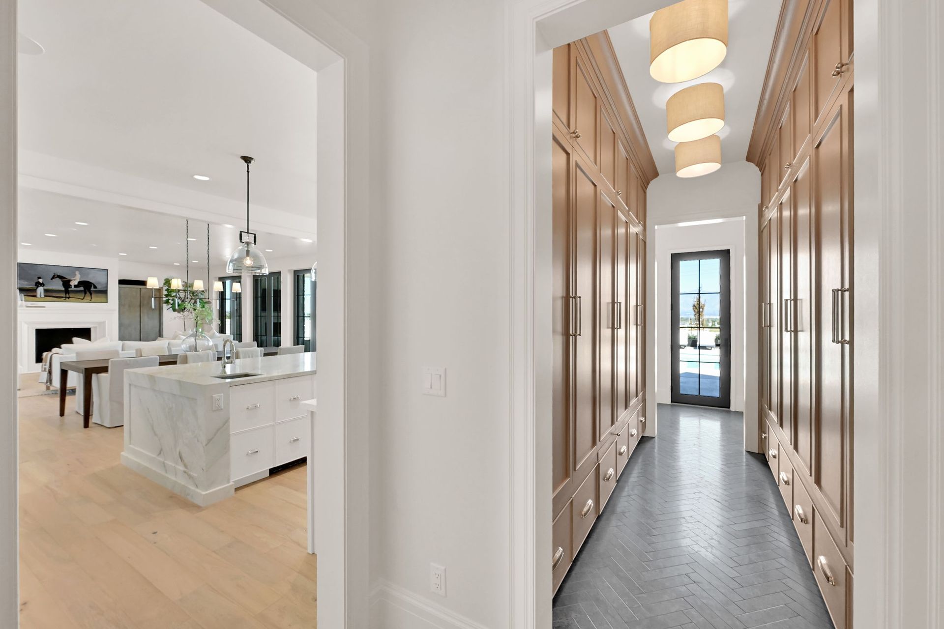 A long hallway leading to a kitchen and a living room.