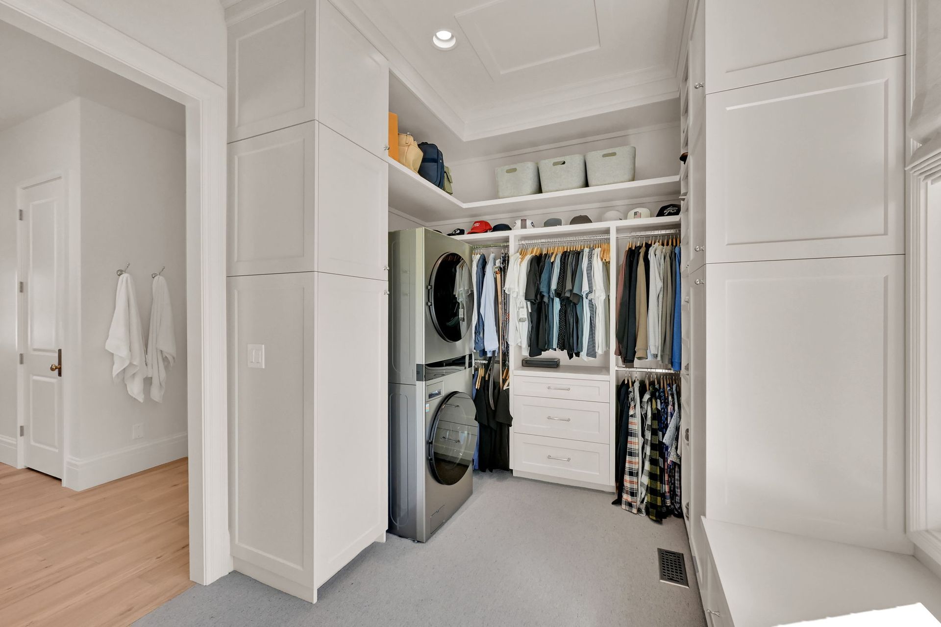A walk in closet with a washer and dryer in it.