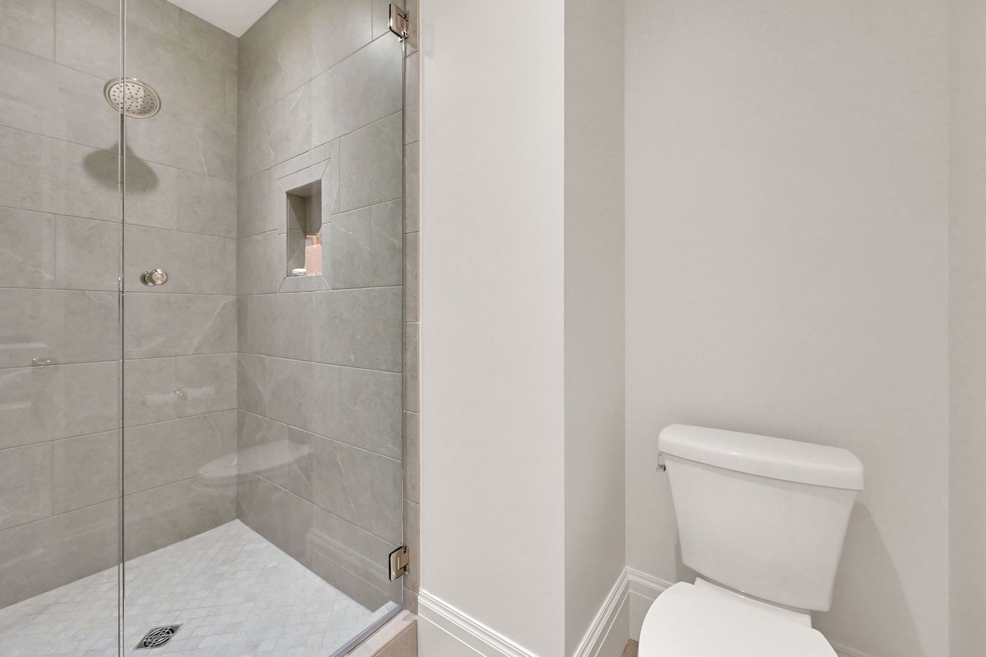 A bathroom with a walk in shower and a toilet.