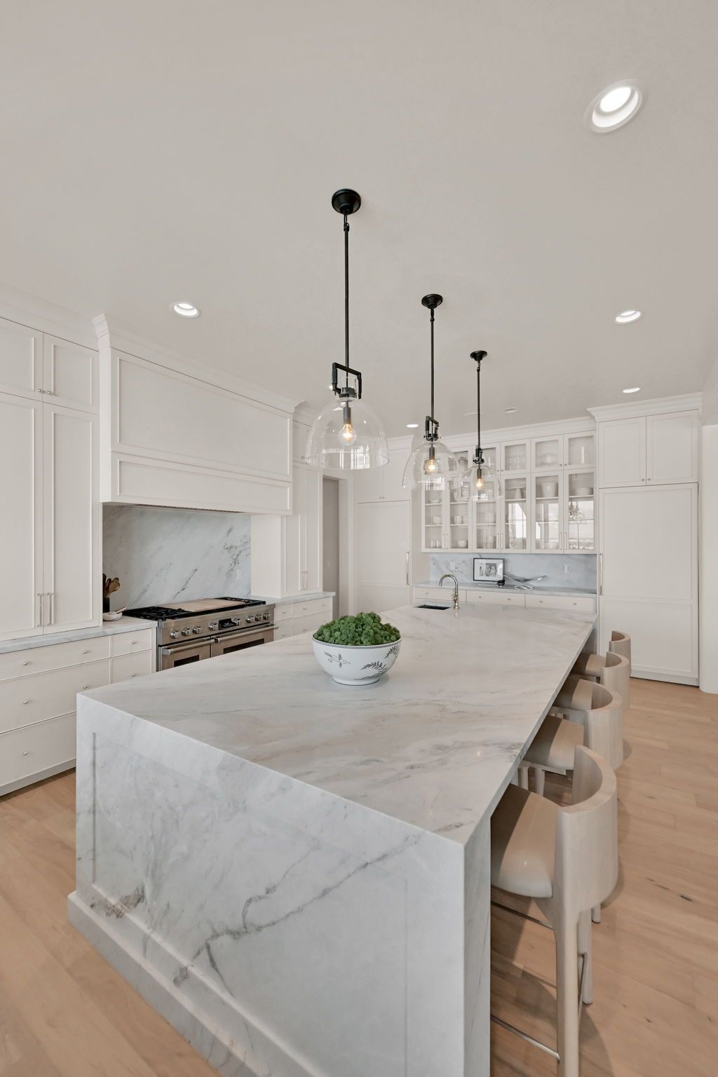 A kitchen with a large island and marble counter tops.