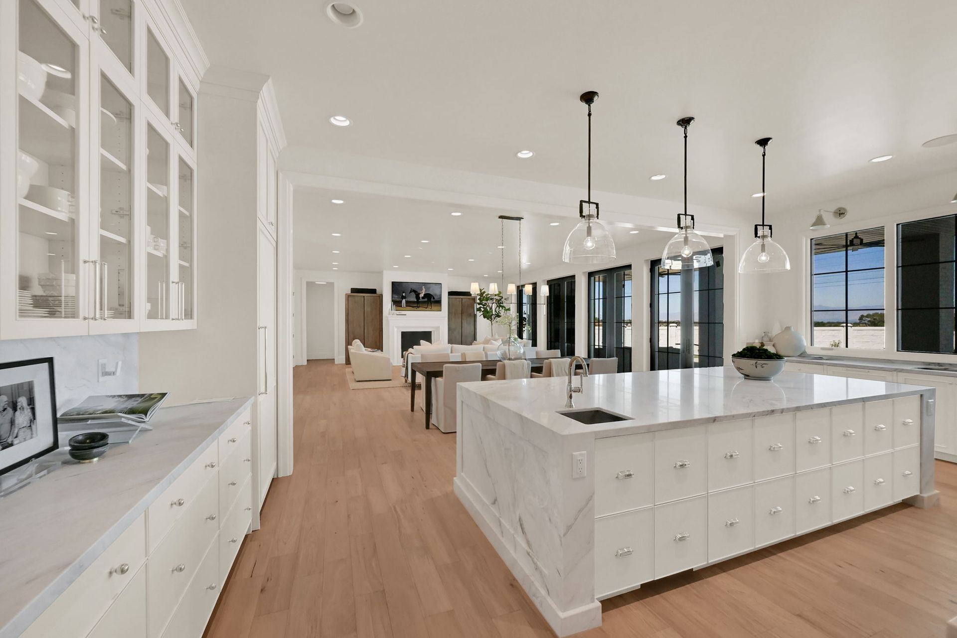 A large kitchen with white cabinets and marble counter tops