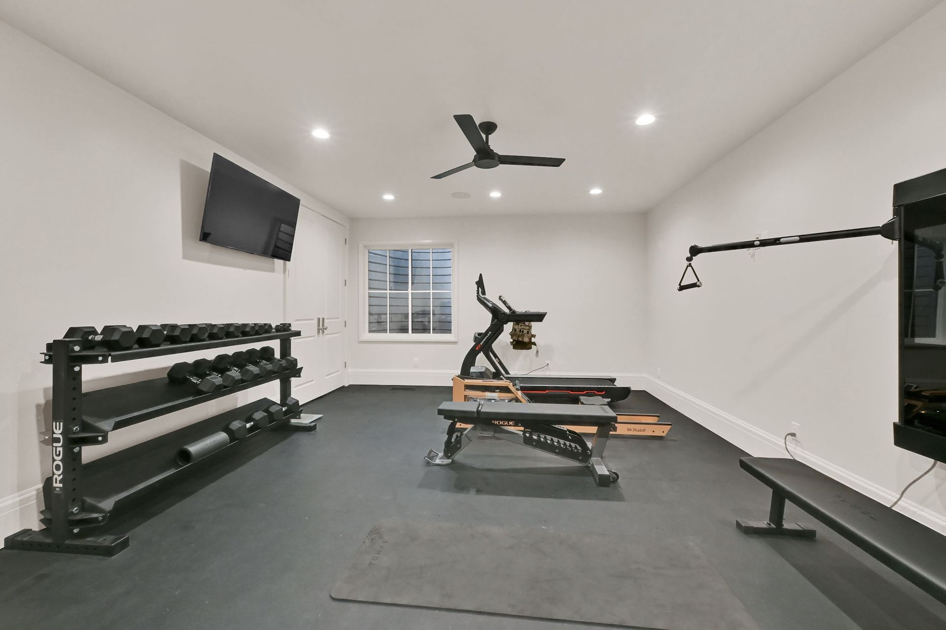 A home gym with a treadmill and a bench