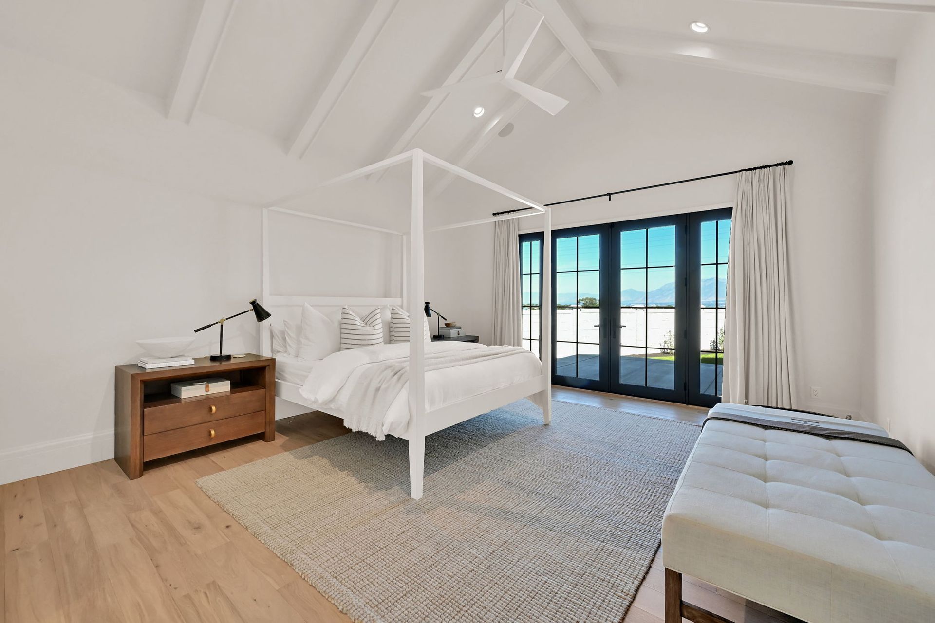 A bedroom with a canopy bed and a bench
