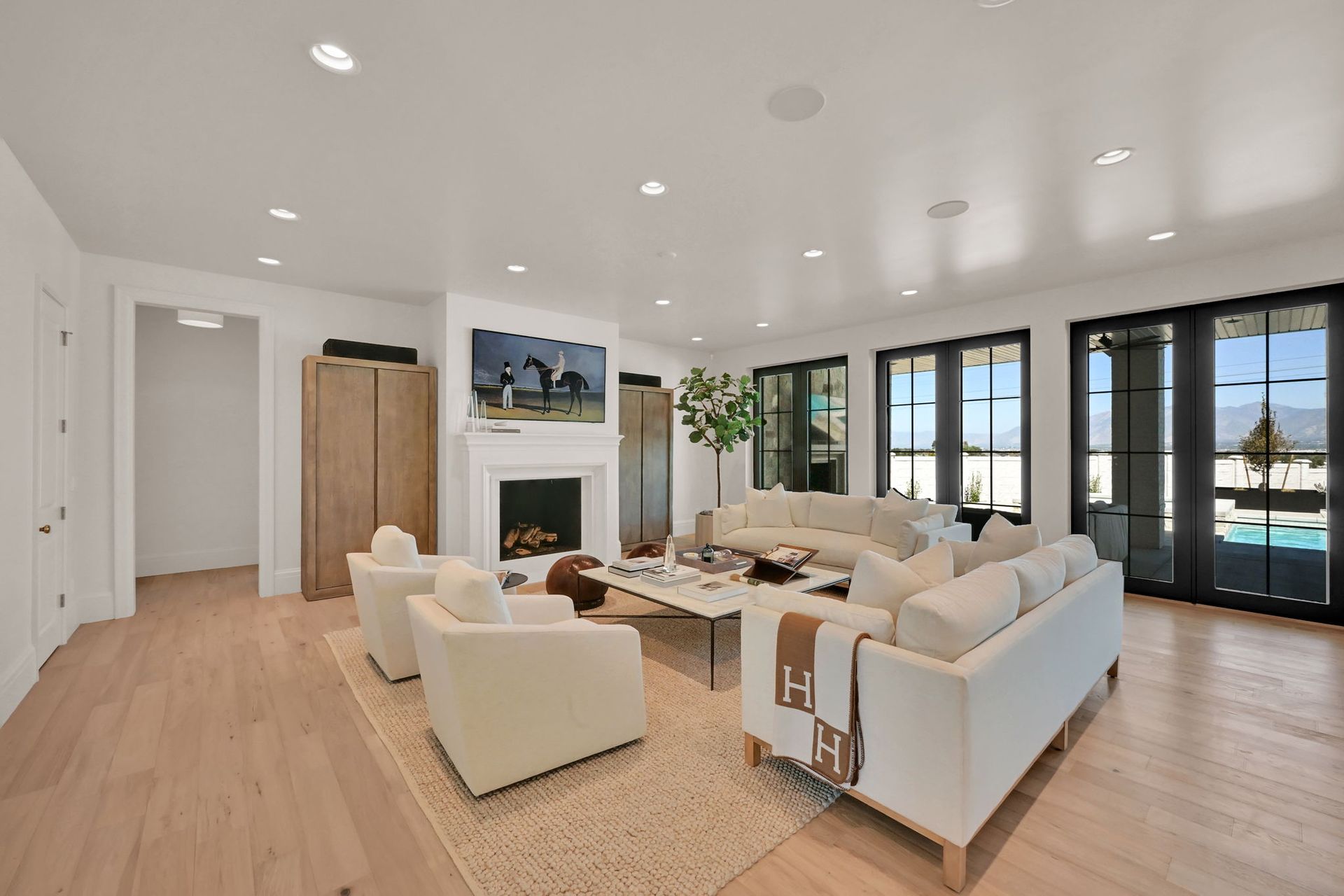 A living room with white furniture and a fireplace