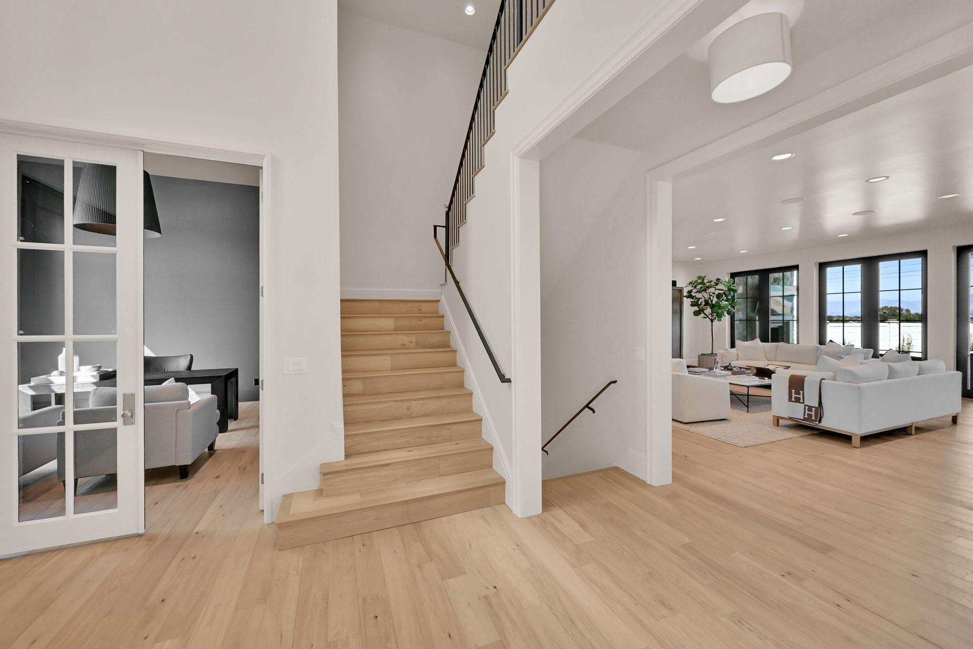 A living room with hardwood floors and stairs leading up to the second floor.