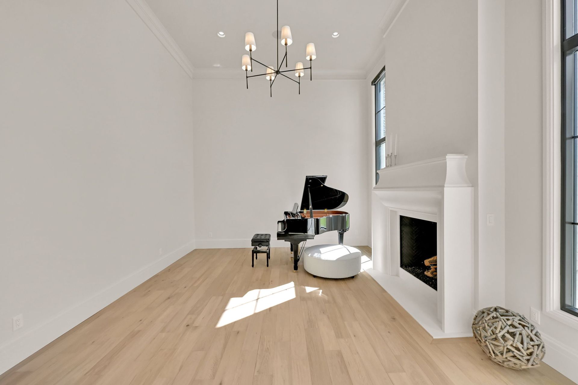 An empty living room with a piano and fireplace.