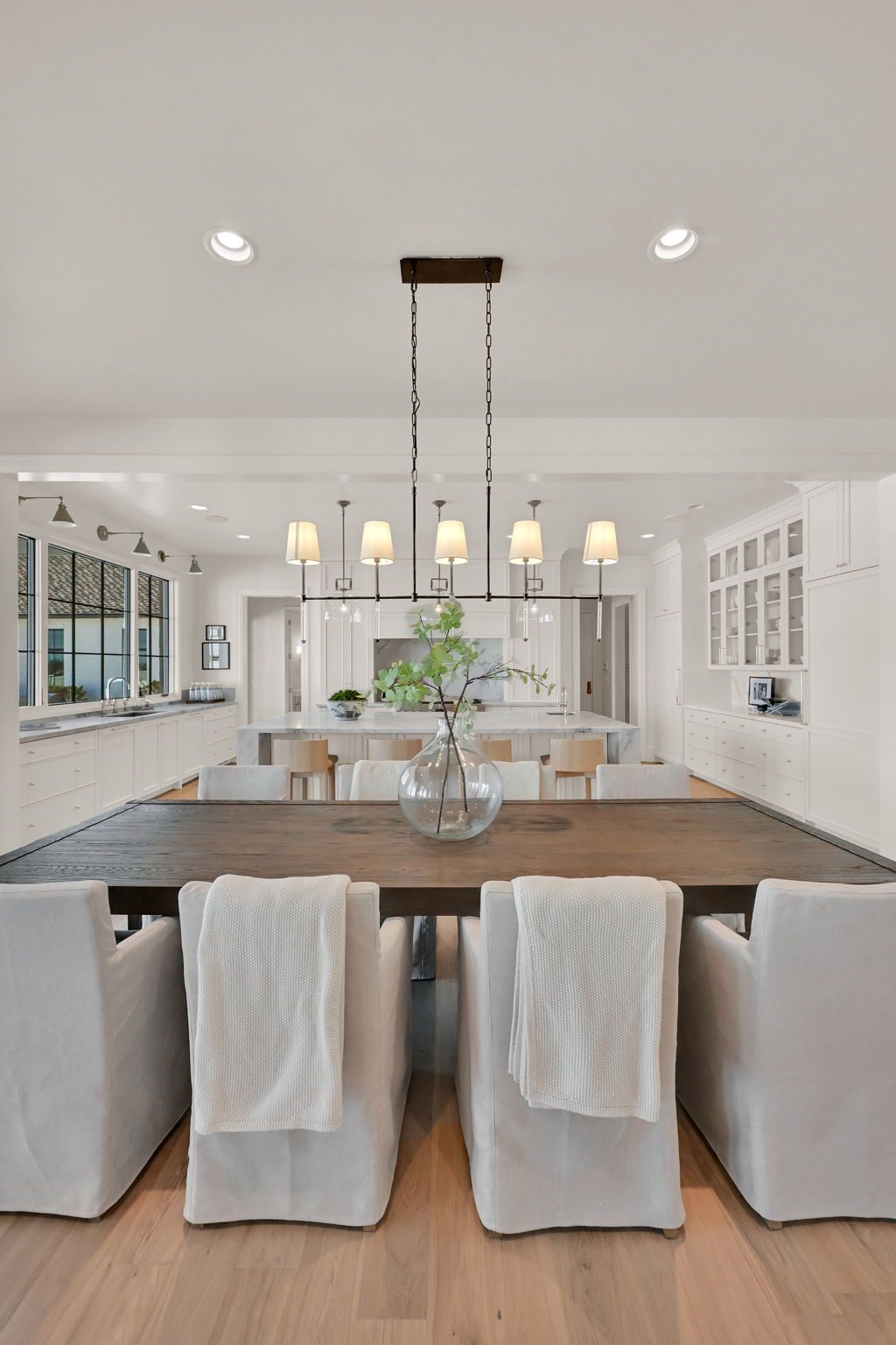 A dining room with a wooden table and white chairs