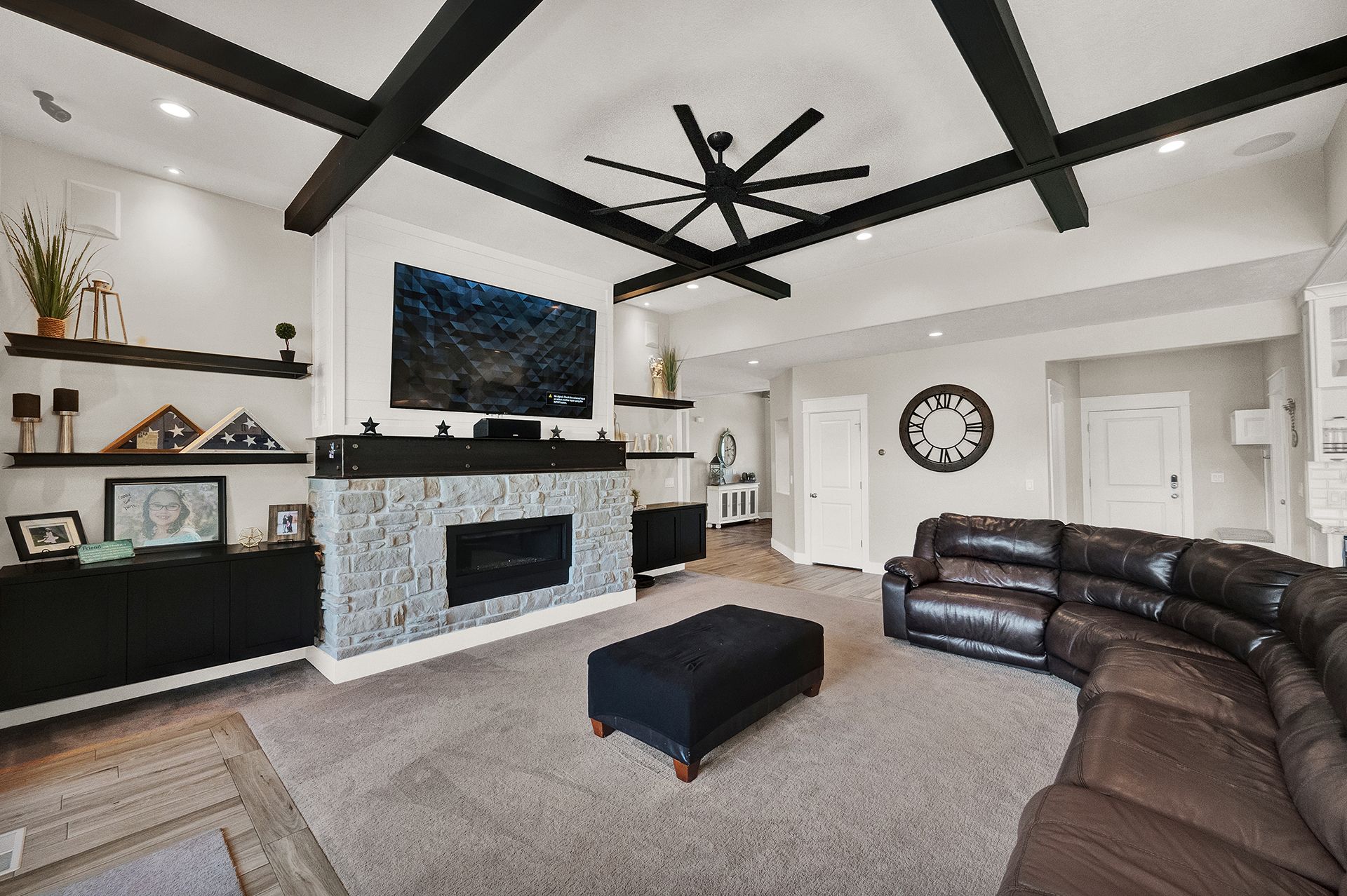 A living room with a couch , fireplace and ceiling fan.