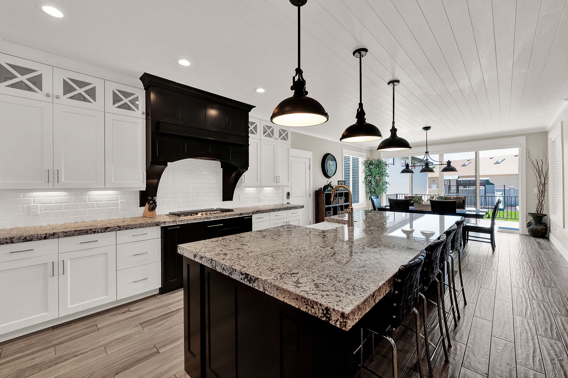 A kitchen with white cabinets , granite counter tops , and a large island.