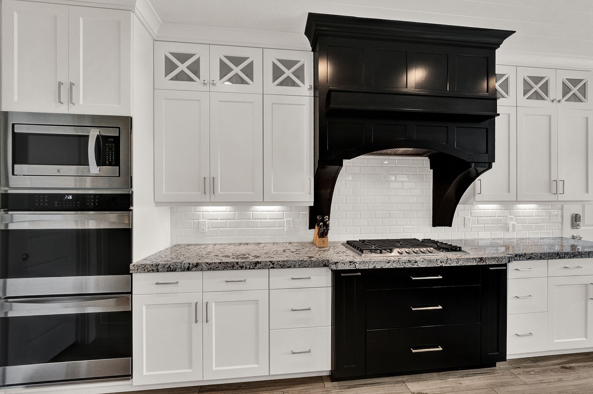 A kitchen with white cabinets and black appliances