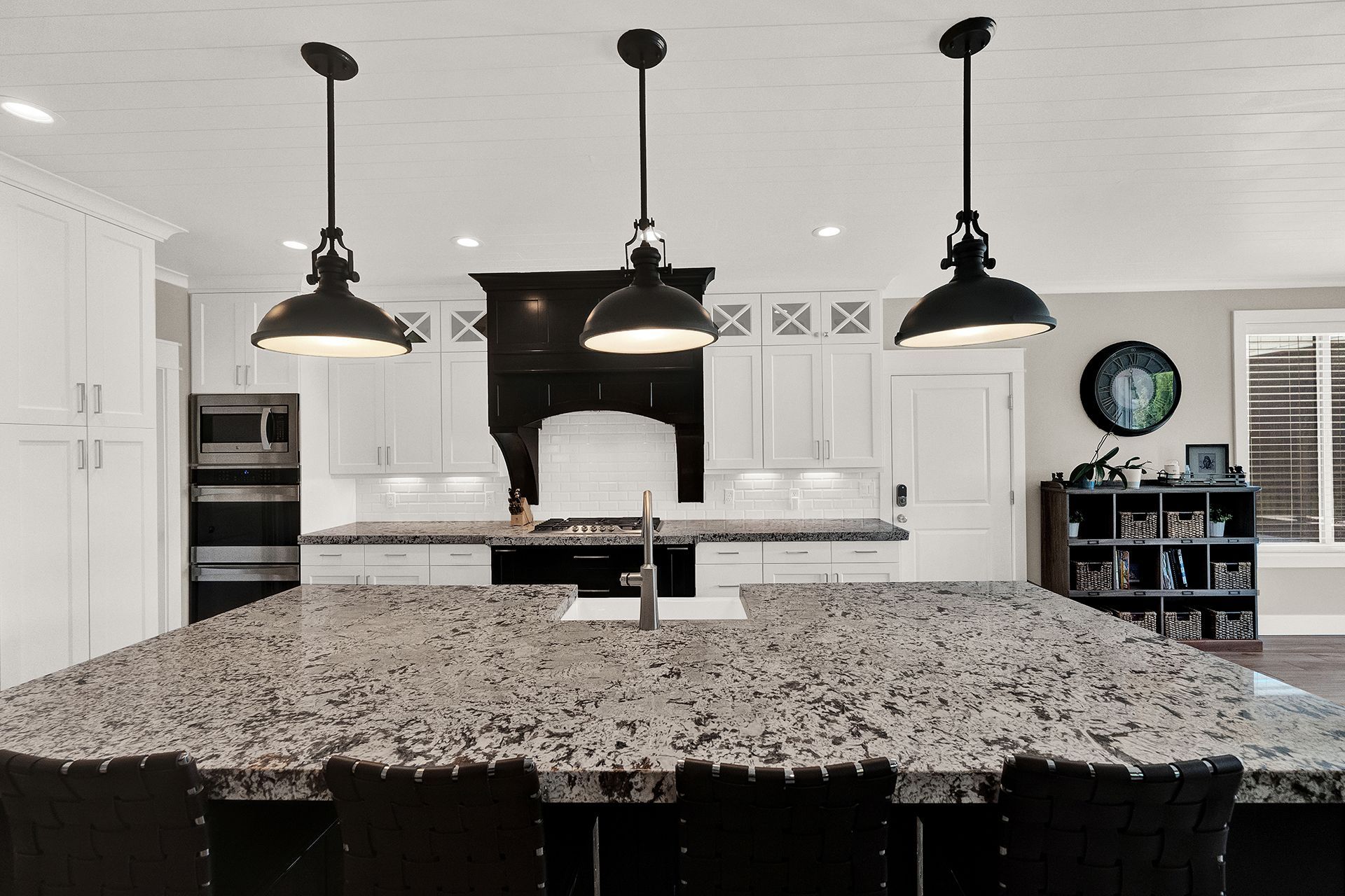 A kitchen with granite counter tops and white cabinets