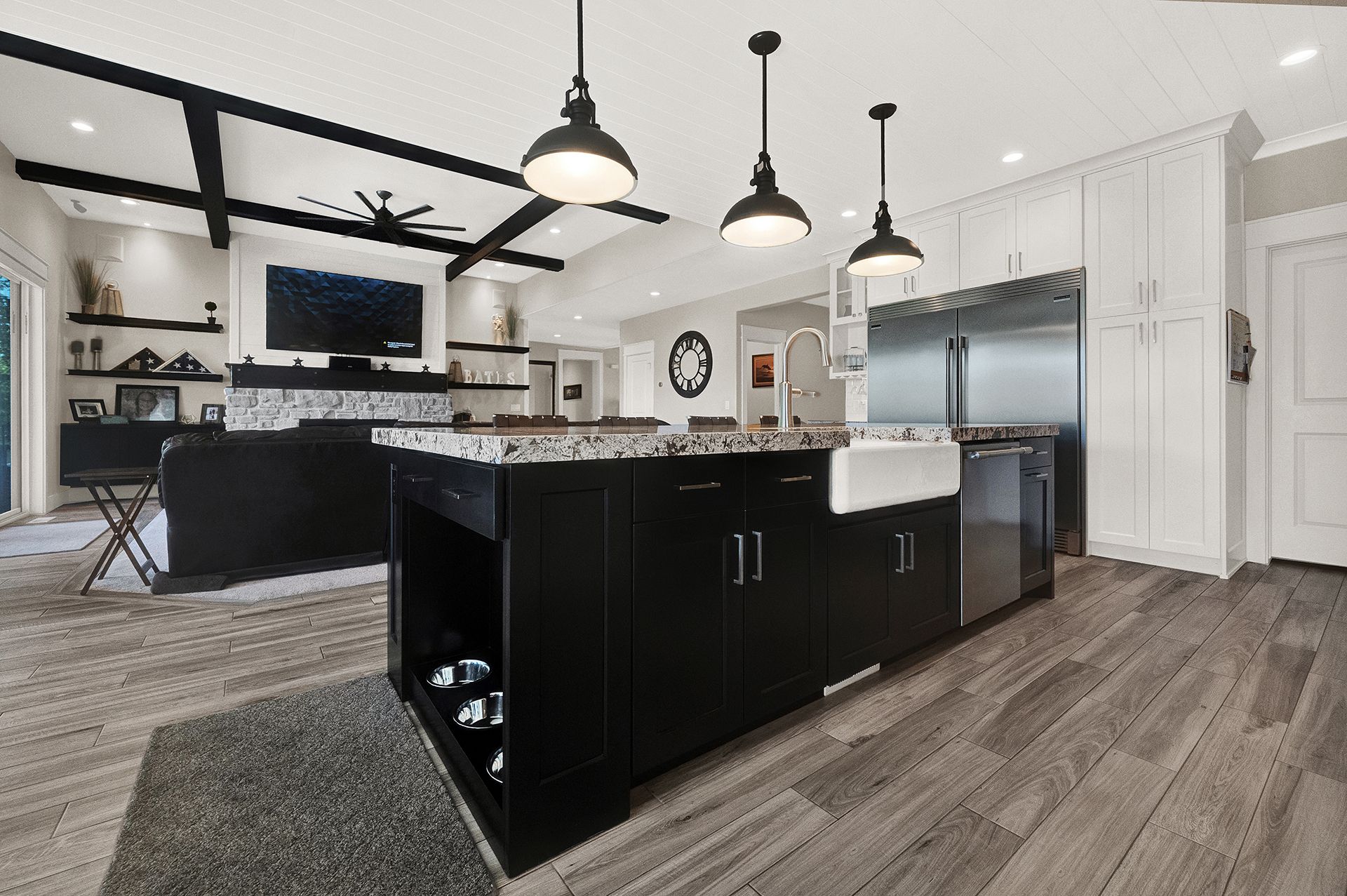A kitchen with black cabinets and stainless steel appliances