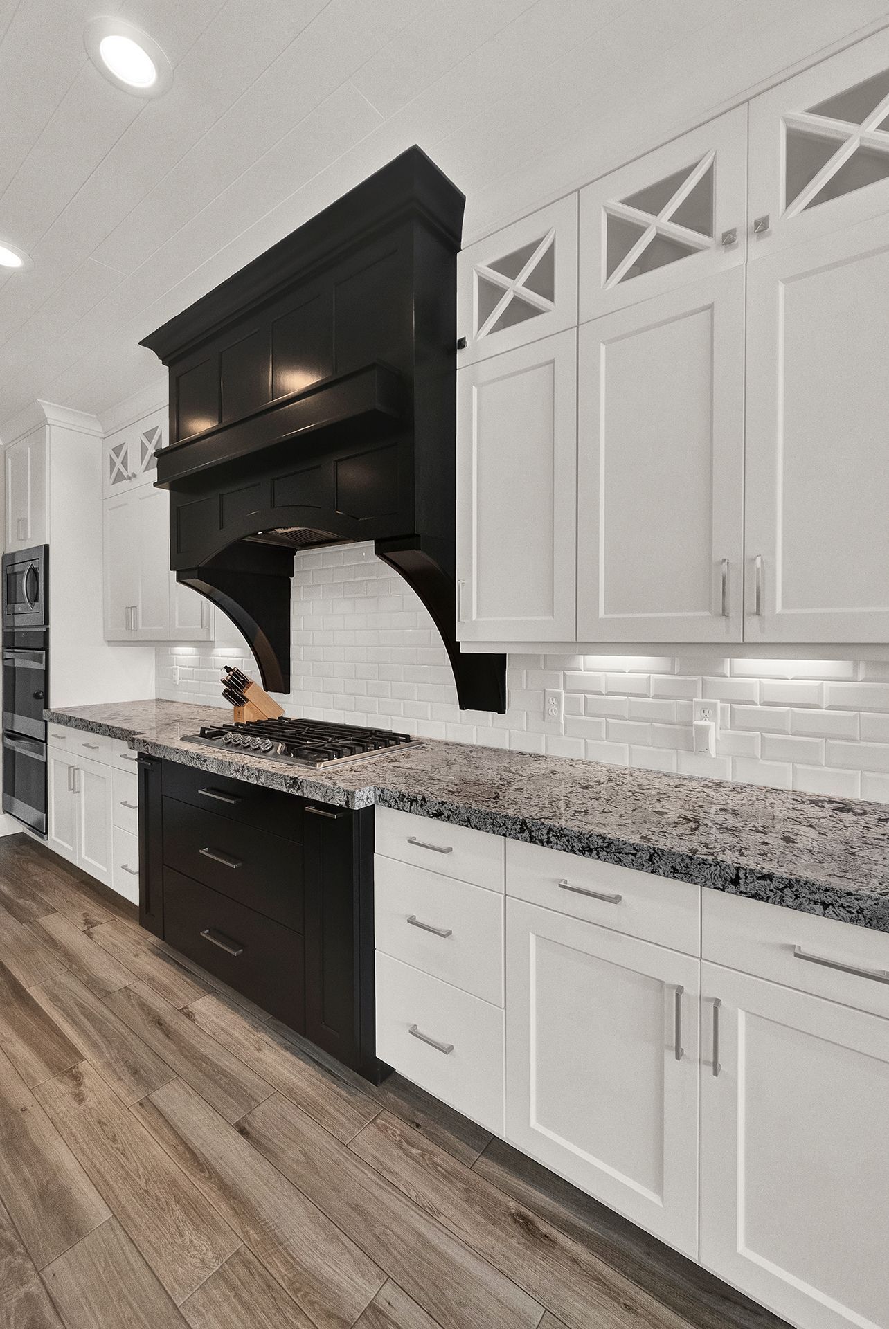 A kitchen with black and white cabinets and granite counter tops.