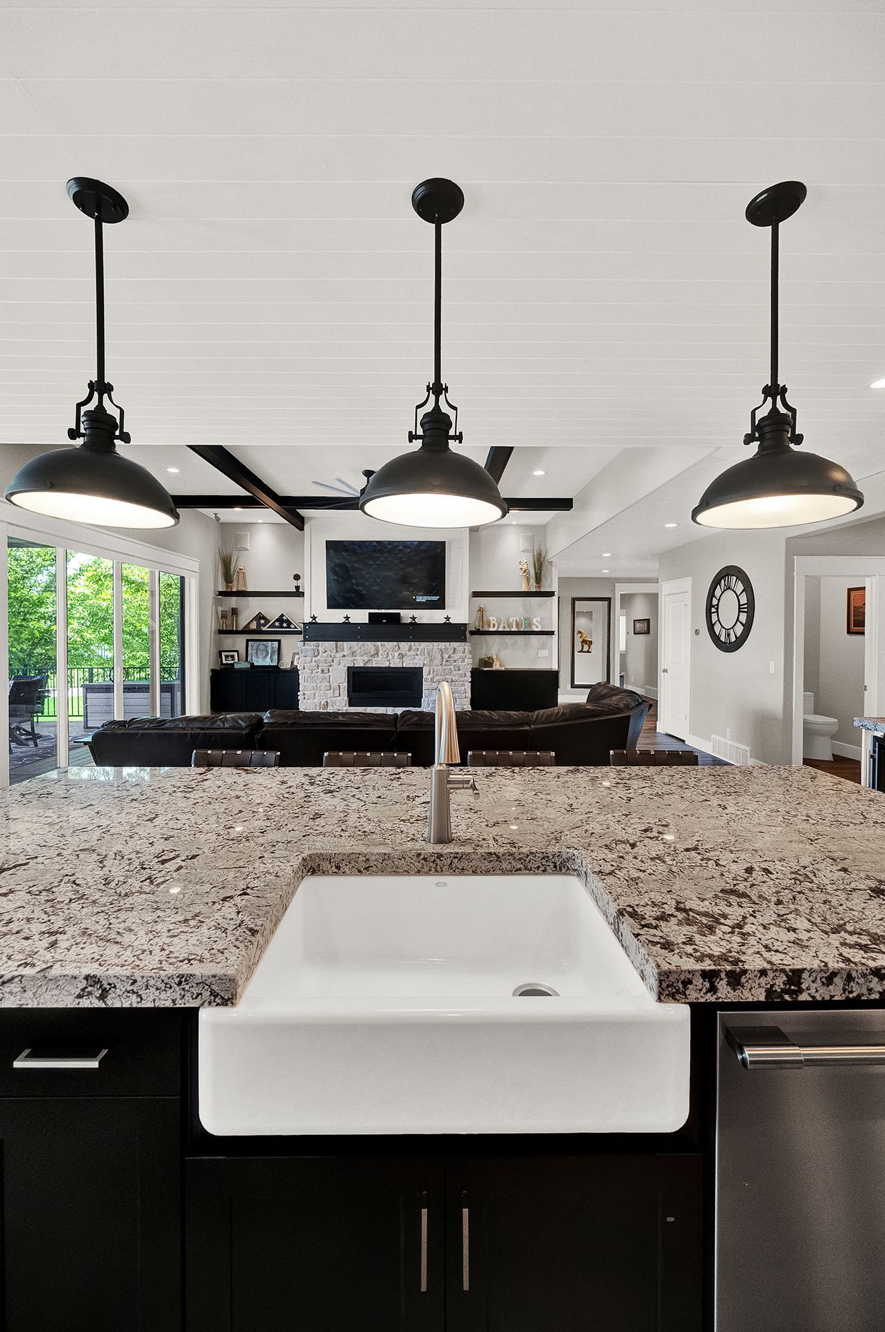 A kitchen with a white sink and granite counter tops.