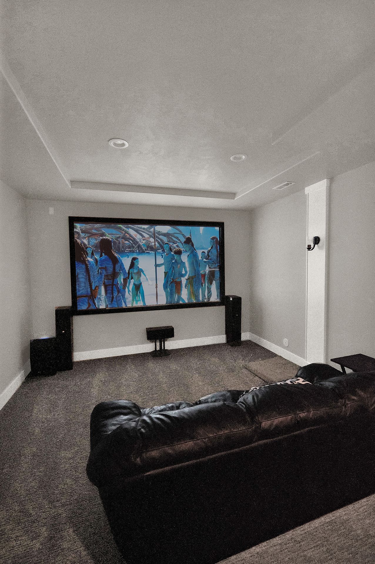 A home theater with a large screen and a couch.